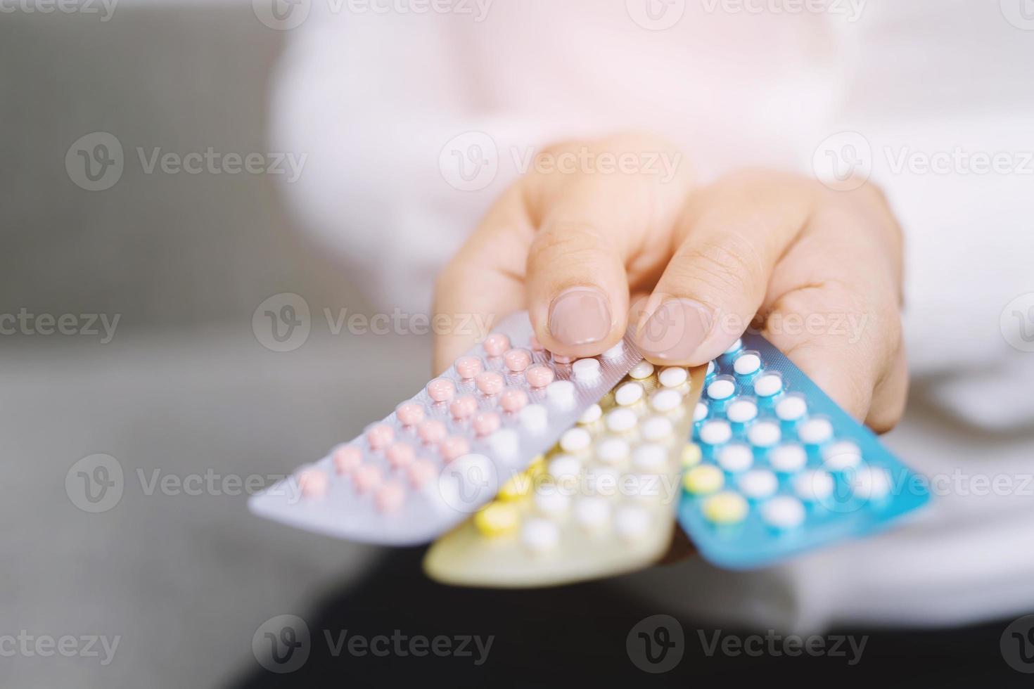 close up woman holding birth control pills The concept methods of contraception gynecology. photo