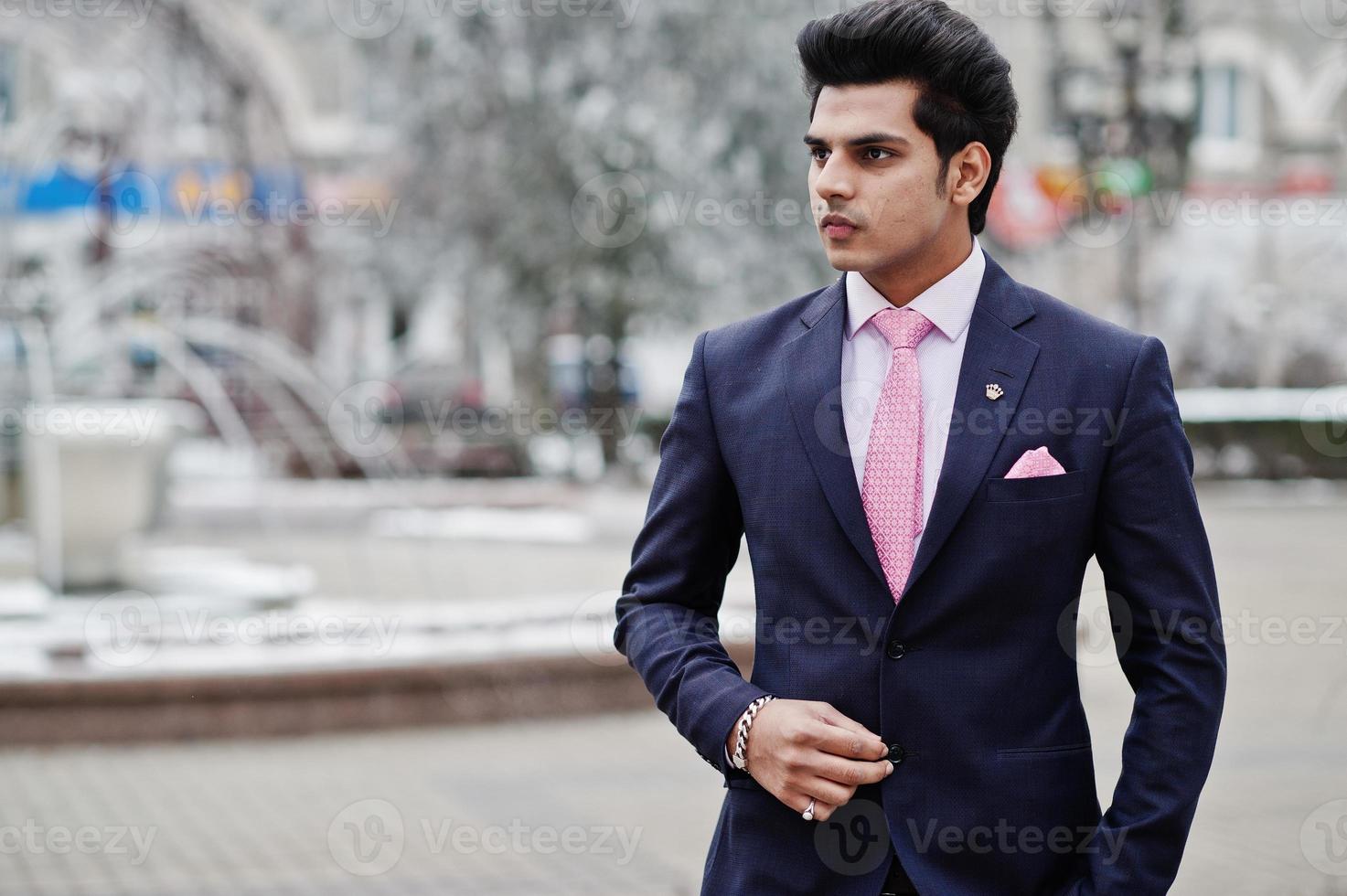 Elegant indian macho man model on suit and pink tie posed on winter day. photo