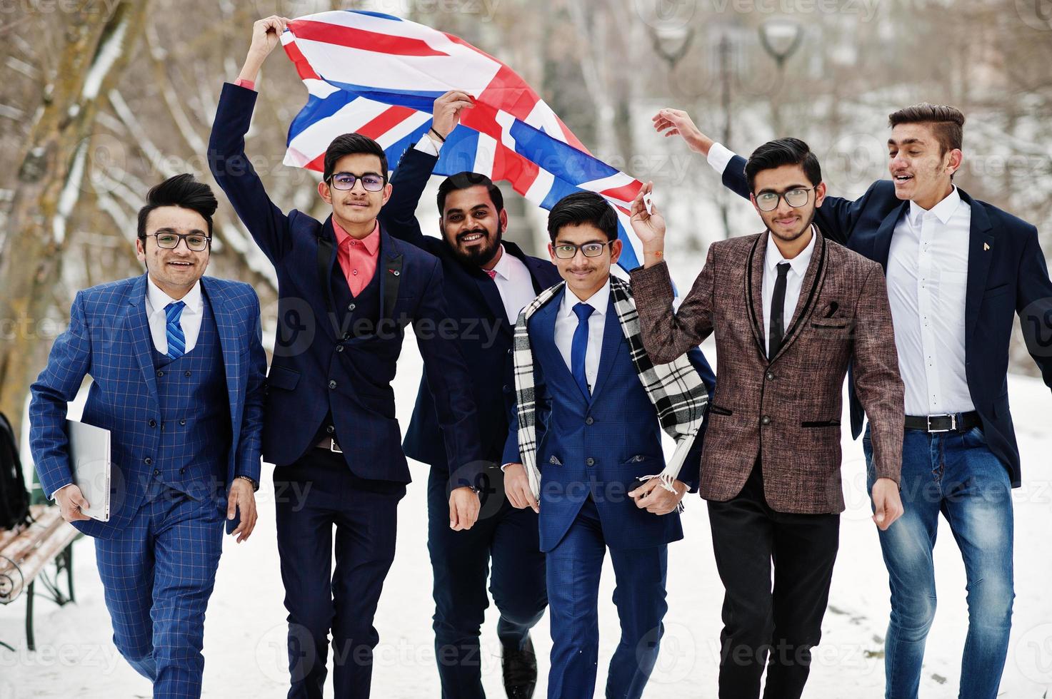 Group of six indian businessman in suits posed outdoor in winter day at Europe with flag of Great Britain. Friendly relations with India and UK. photo