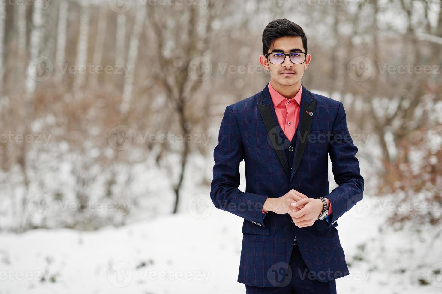 Elegante estudiante indio con traje y gafas posó en el día de invierno al aire libre. foto