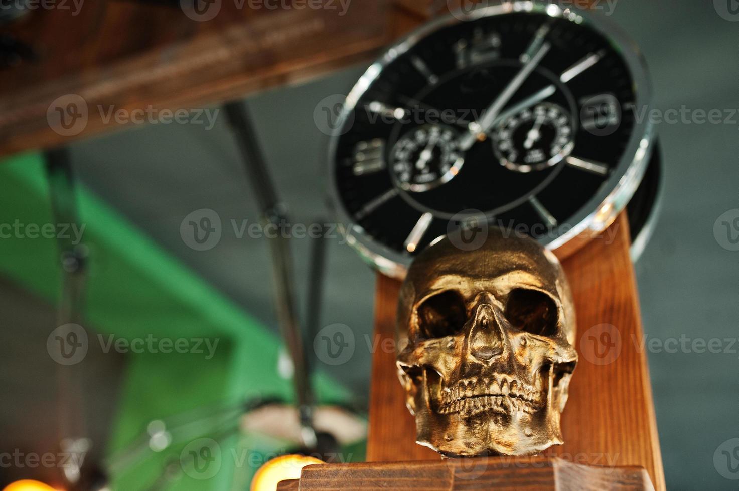 Bronze skull against clock at barber shop. photo