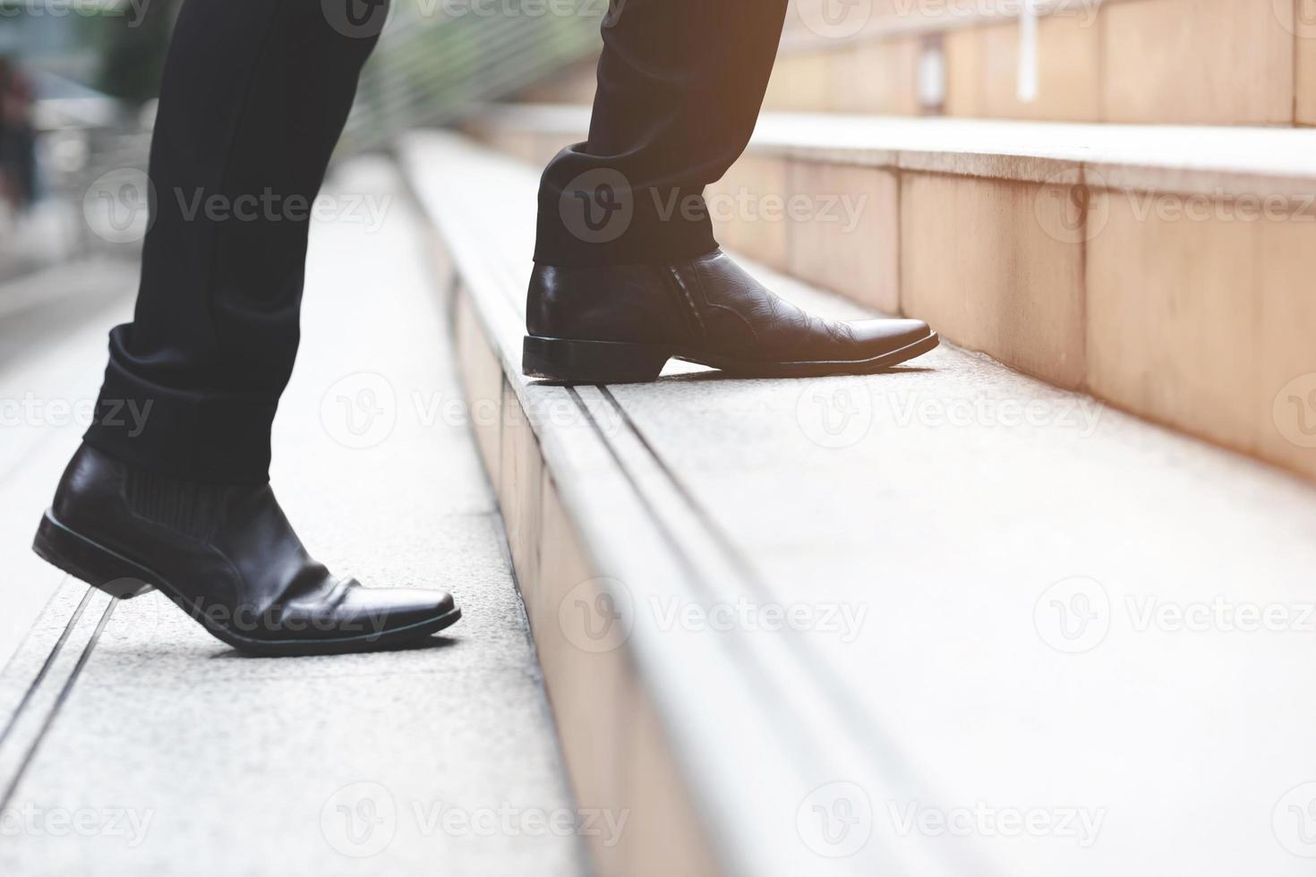 hombre de negocios moderno trabajando piernas de primer plano subiendo las escaleras en la ciudad moderna. en hora punta para trabajar en la oficina de prisa. durante la primera mañana de trabajo. escalera foto