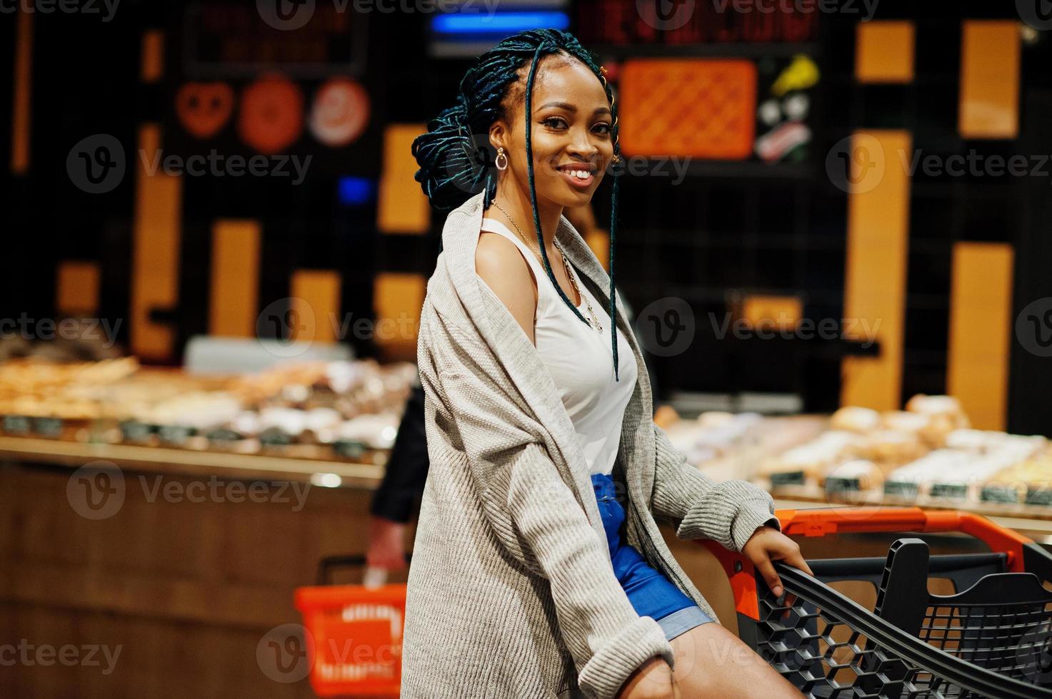 African american woman with shopping cart trolley in the supermarket ...