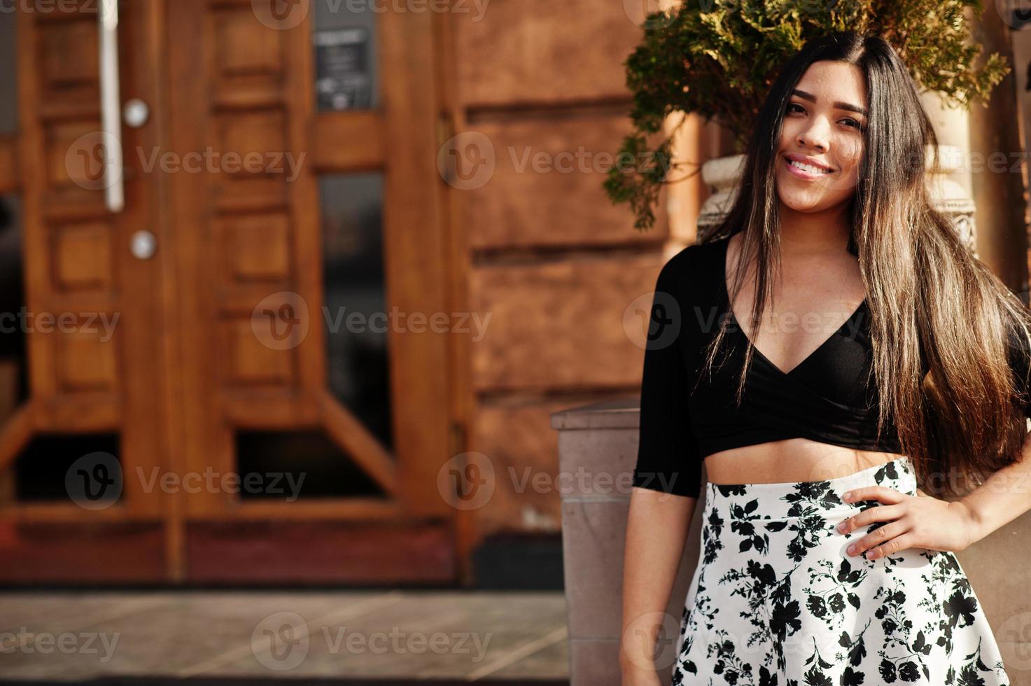 Pretty latino model girl from Ecuador wear on black tops and skirt posed at street. photo
