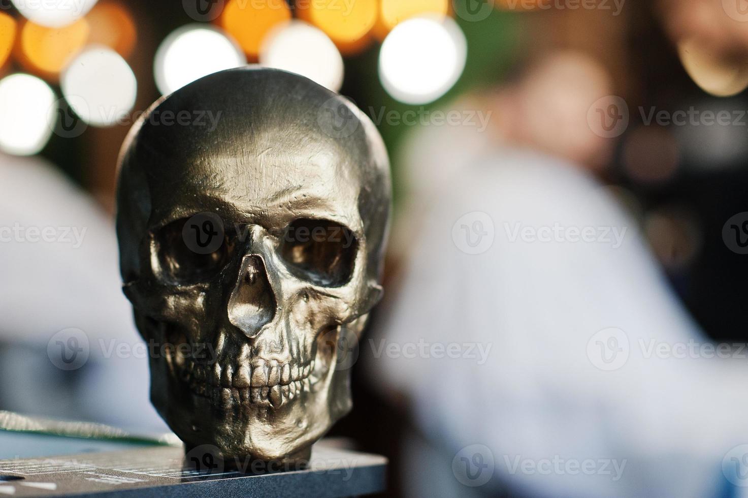 Bronze skull against blur bokeh of barber shop. photo