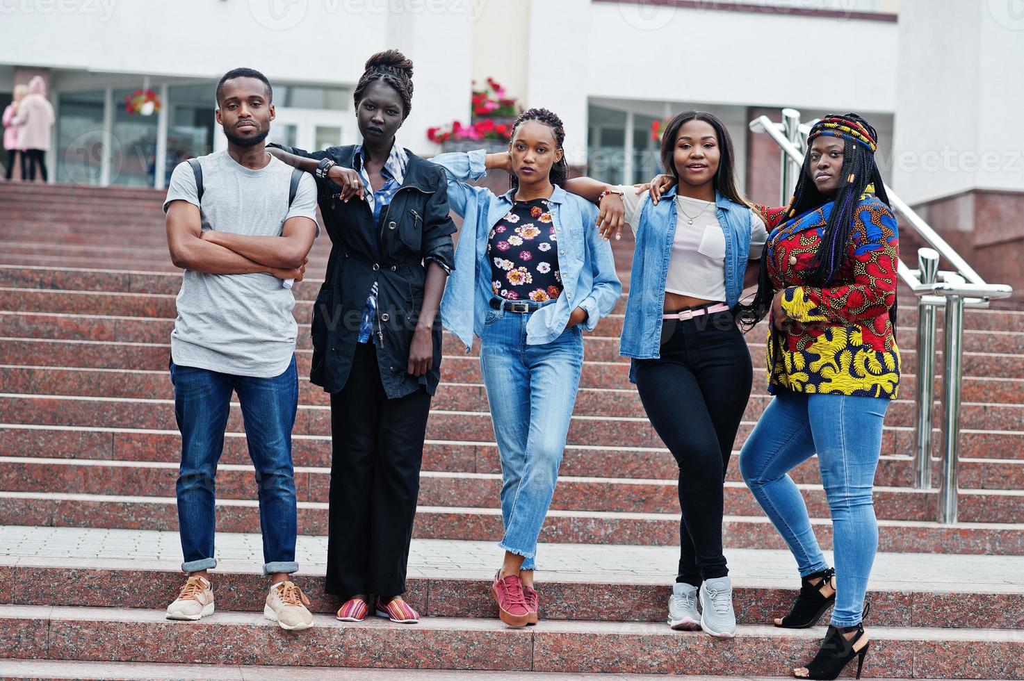 grupo de cinco estudiantes universitarios africanos que pasan tiempo juntos en el campus en el patio de la universidad. amigos negros afro estudiando. tema de la educación foto