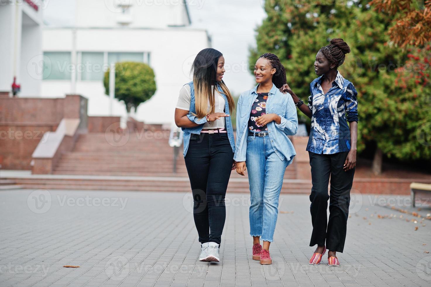 grupo de jóvenes amigas negras pasando el rato en la ciudad. mujeres africanas multirraciales caminando por la calle y discutiendo. foto