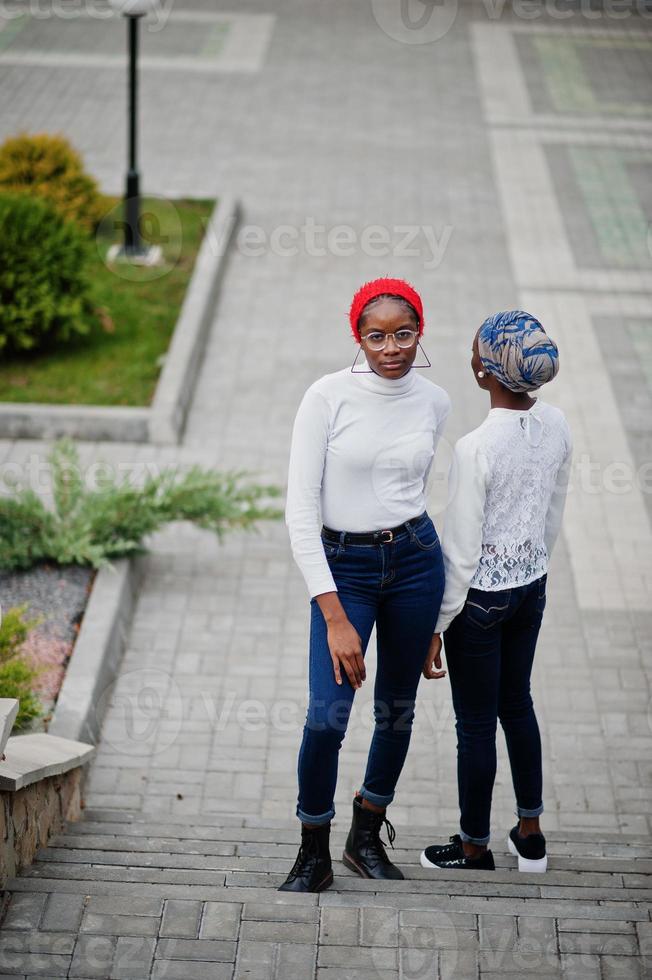 Two young modern fashionable, attractive, tall and slim african muslim womans in hijab or turban head scarf posed together. photo