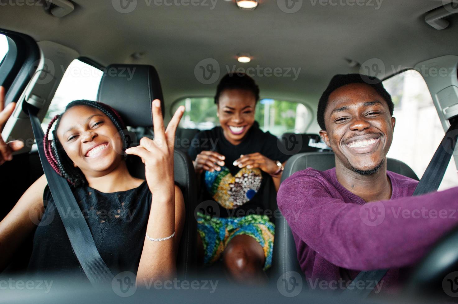 Young african american friends sitting inside a car. photo