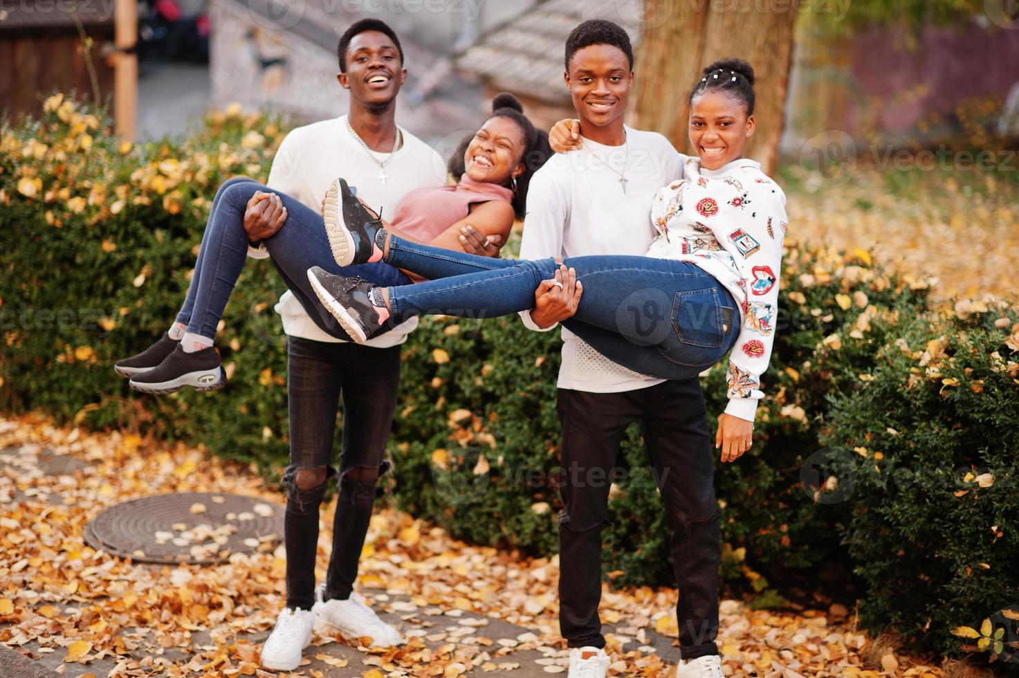 cuatro amigos africanos caminando por las calles de una ciudad antigua en un día soleado de otoño. foto