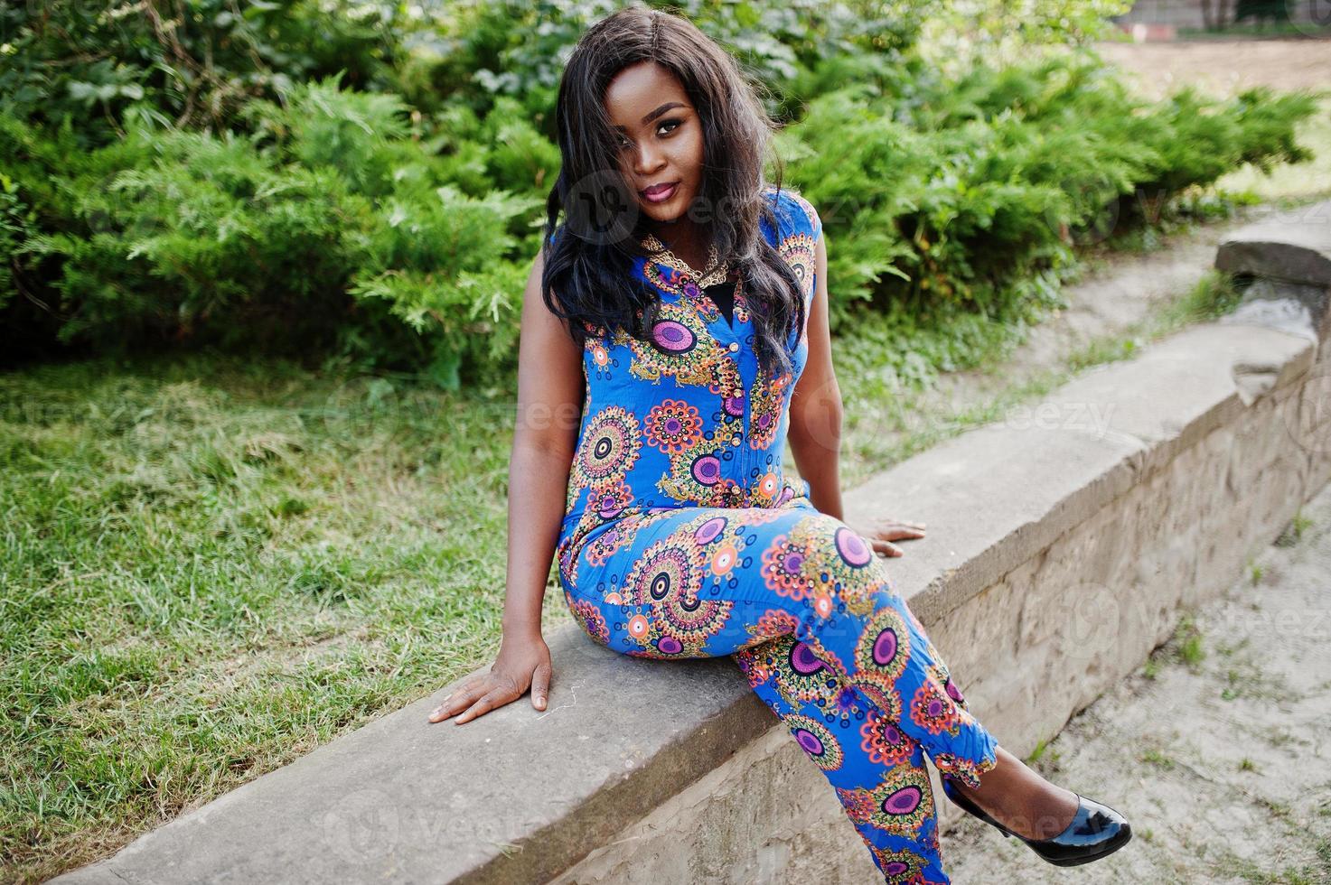 African american girl in coloured clothes sitting outdoor. Fashionable black woman. photo