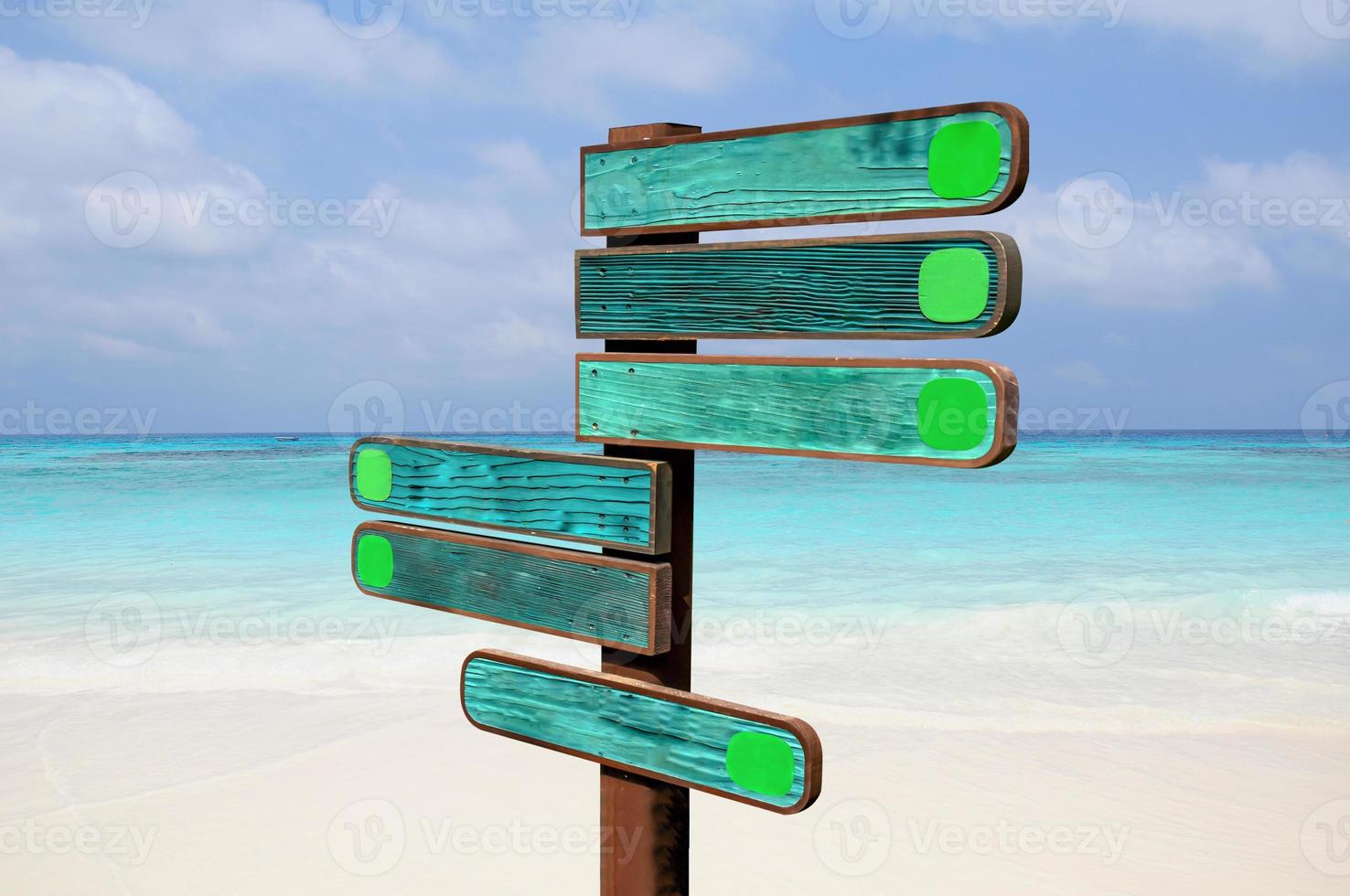 Wood signs for travel directions on the beach with sea and blue sky background. photo