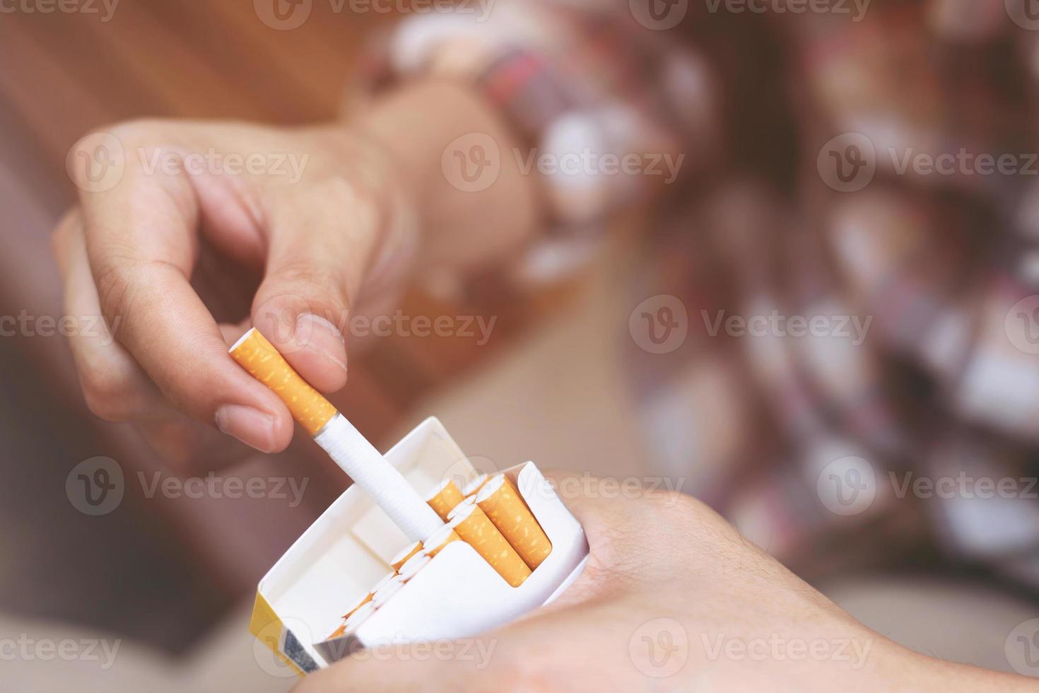 close up man hand holding peel it off cigarette pack prepare smoking a cigarette. Packing line up. photo filters Natural light.