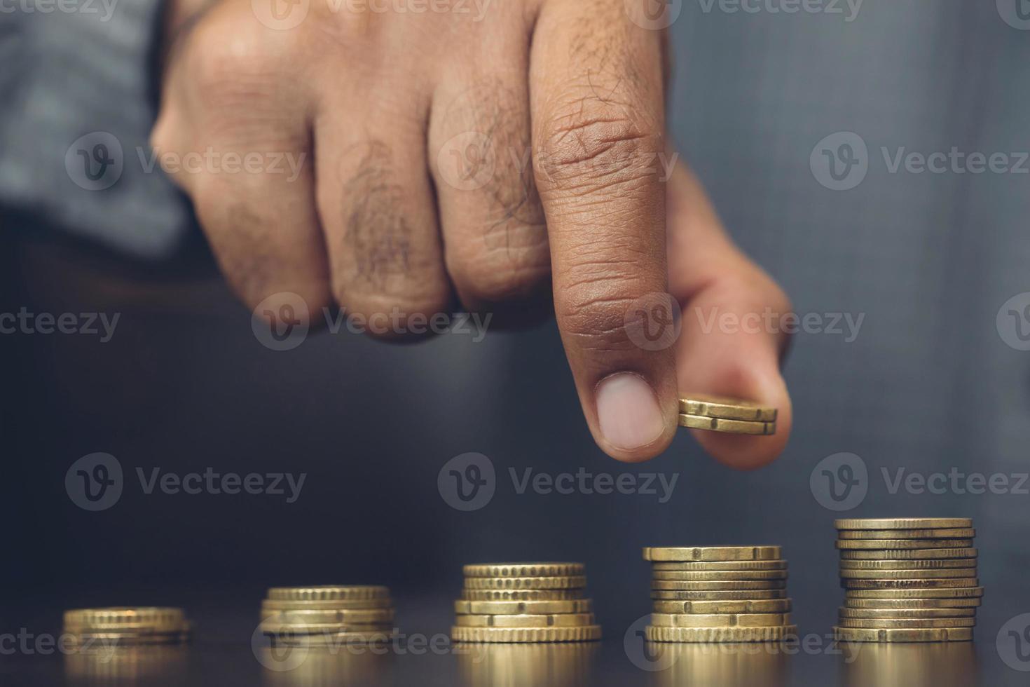 Saving money. businessman hand putting stack coins to show concept of growing savings money finance business and wealthy.  soft focus. Leave space to write a description of the message. photo