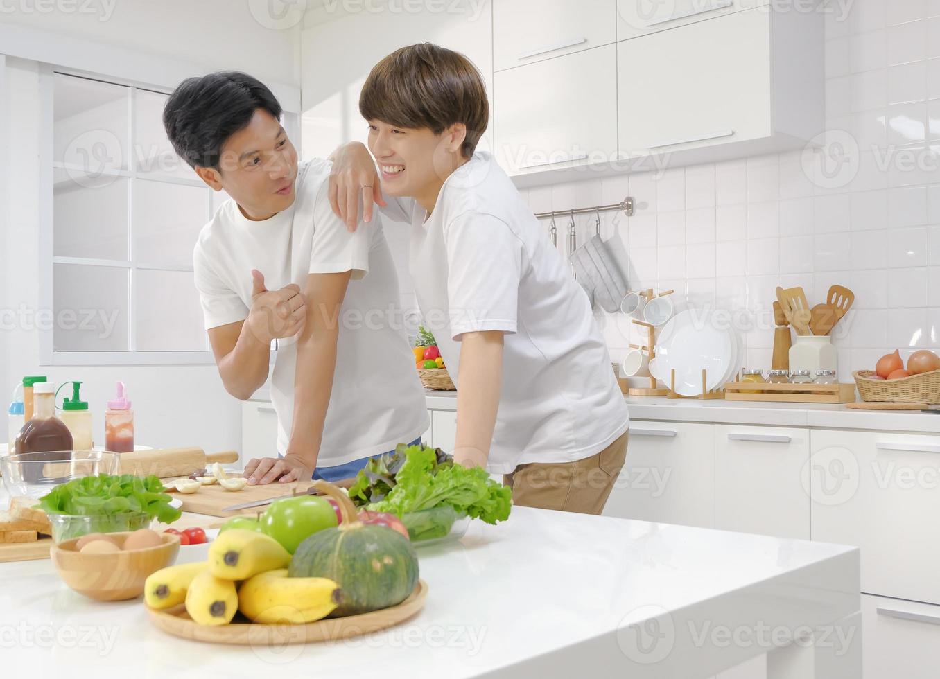 Candid LGBT Asian young man couple domestic life in the white kitchen. Selective focus. photo