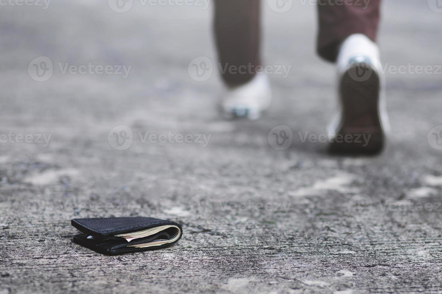 businessman had lost leather wallet with money on the street. Close-up of wallet lying on the sidewalk in during the trip to work. photo