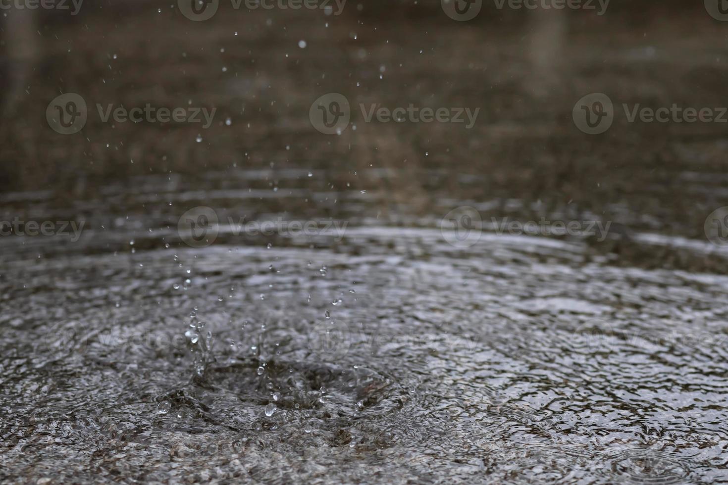 Rain drops in the water heavy on asphalt shade of black shadow and reflection of dark sky in the city. high contrast during autumn photo
