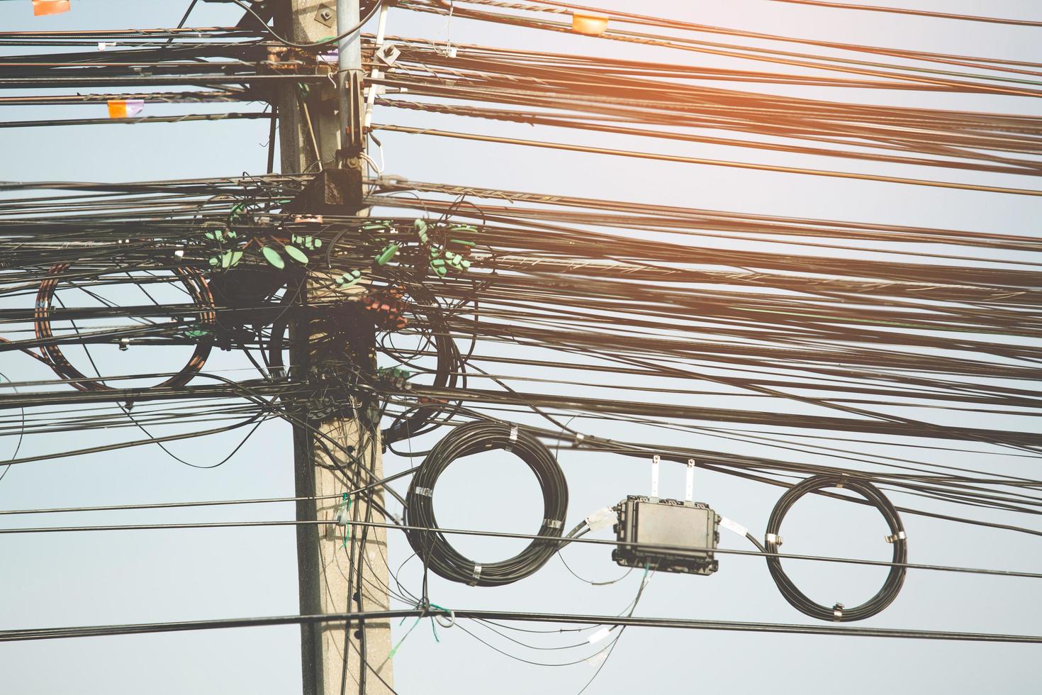 cables eléctricos desordenados y alambres en poste eléctrico foto