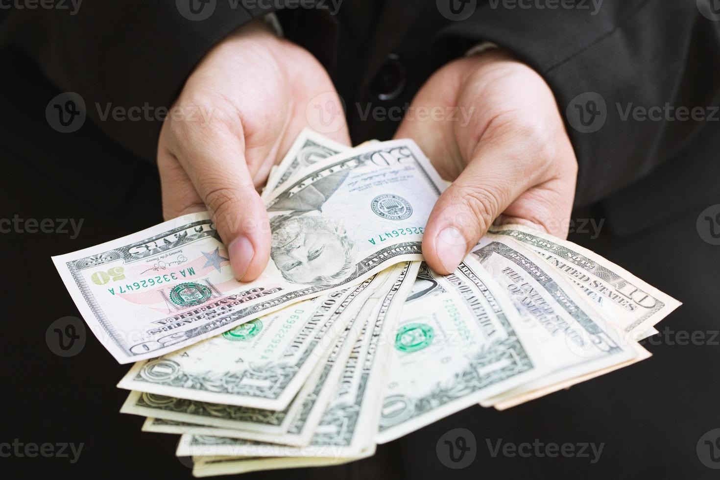 Business man in formal suit hand hold money spread of cash giving money. isolated on a white background photo