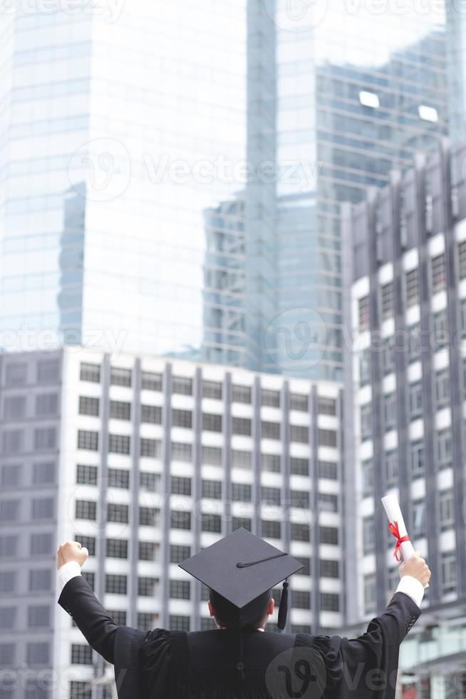 graduate are celebrating graduation. Happiness feeling hand hold show hat and diploma certificate in background School building.  Congratulation education during Commencement day University Degree. photo