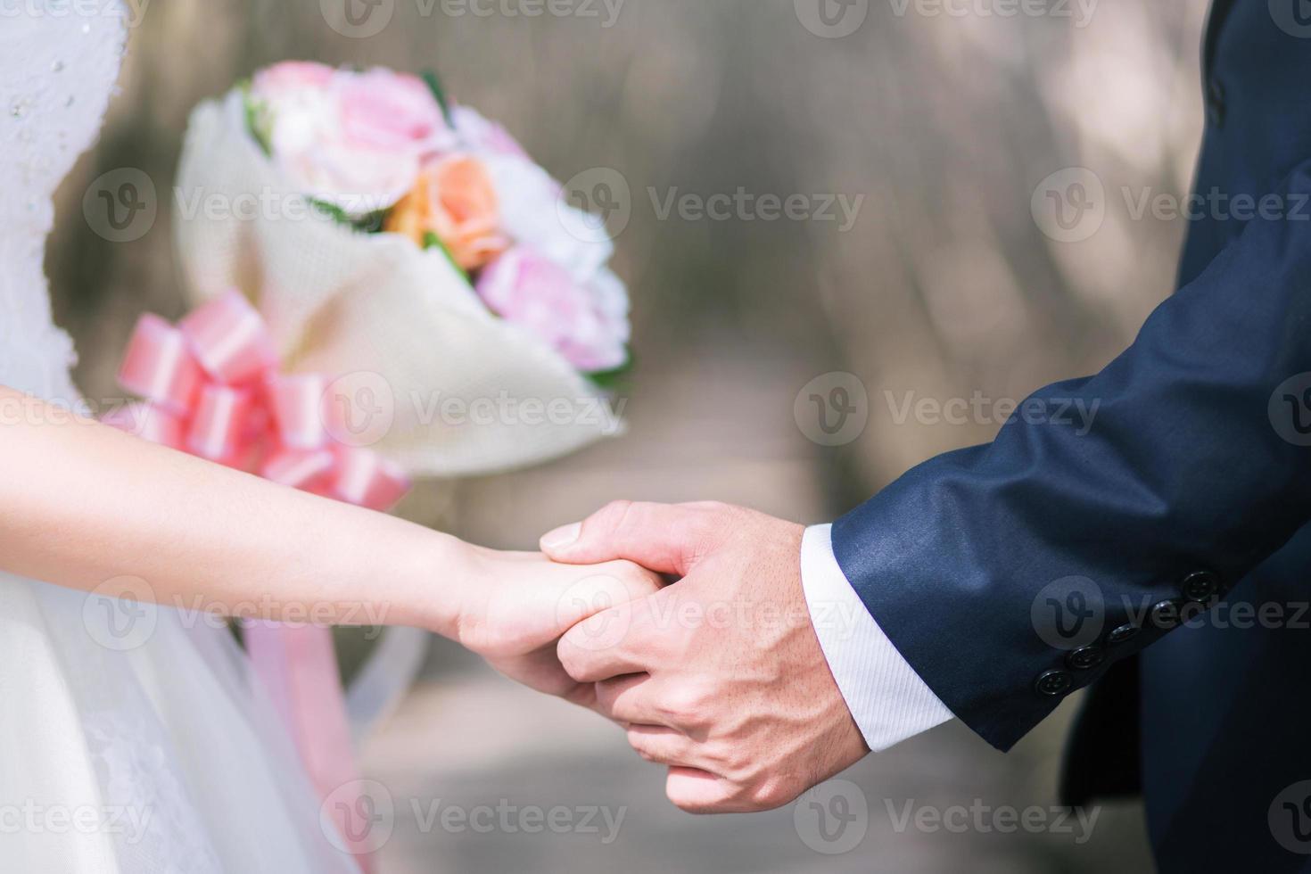 Loving Young love married couple holding hands and stand together in ceremony wedding day marry scene. Young love couple be hand in hand pinky promise or pinky swear. photo