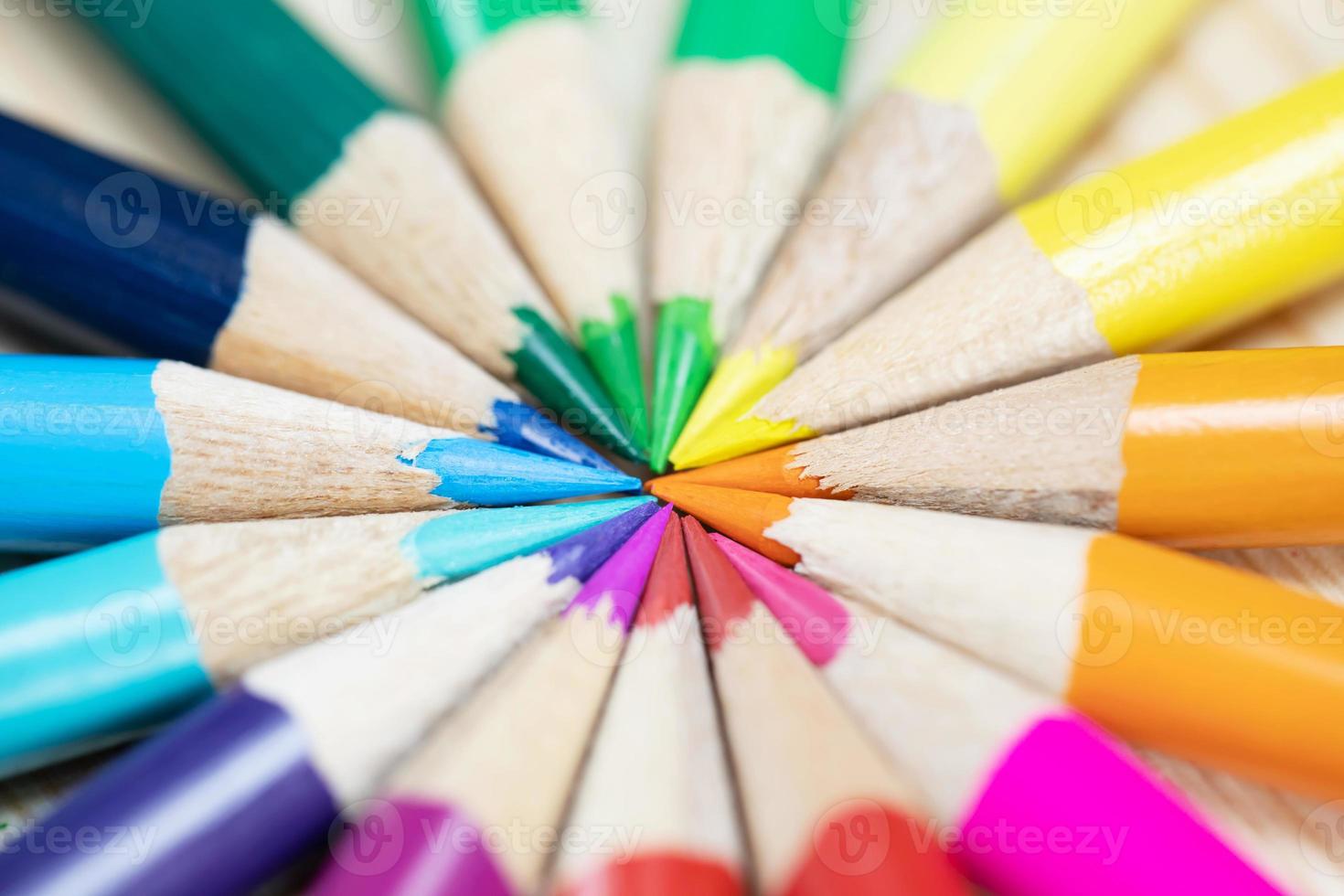 primer plano macro de lápices de colores pila puntas de lápiz en diagonal en un círculo sobre el escritorio de madera. educación de ideas de regreso a la escuela. foto