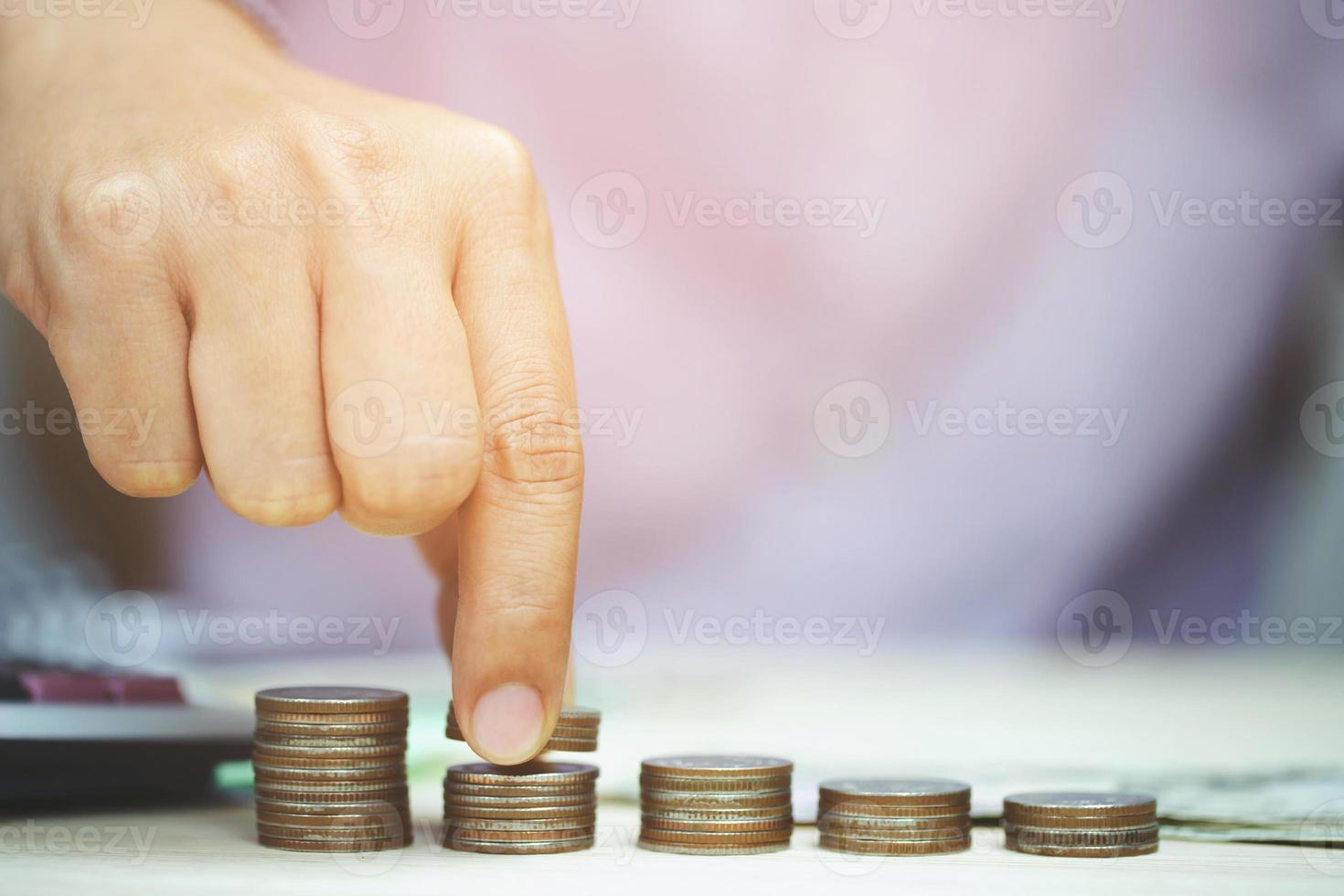 mano poniendo dinero monedas pila creciendo, ahorrando dinero para el concepto de propósito foto