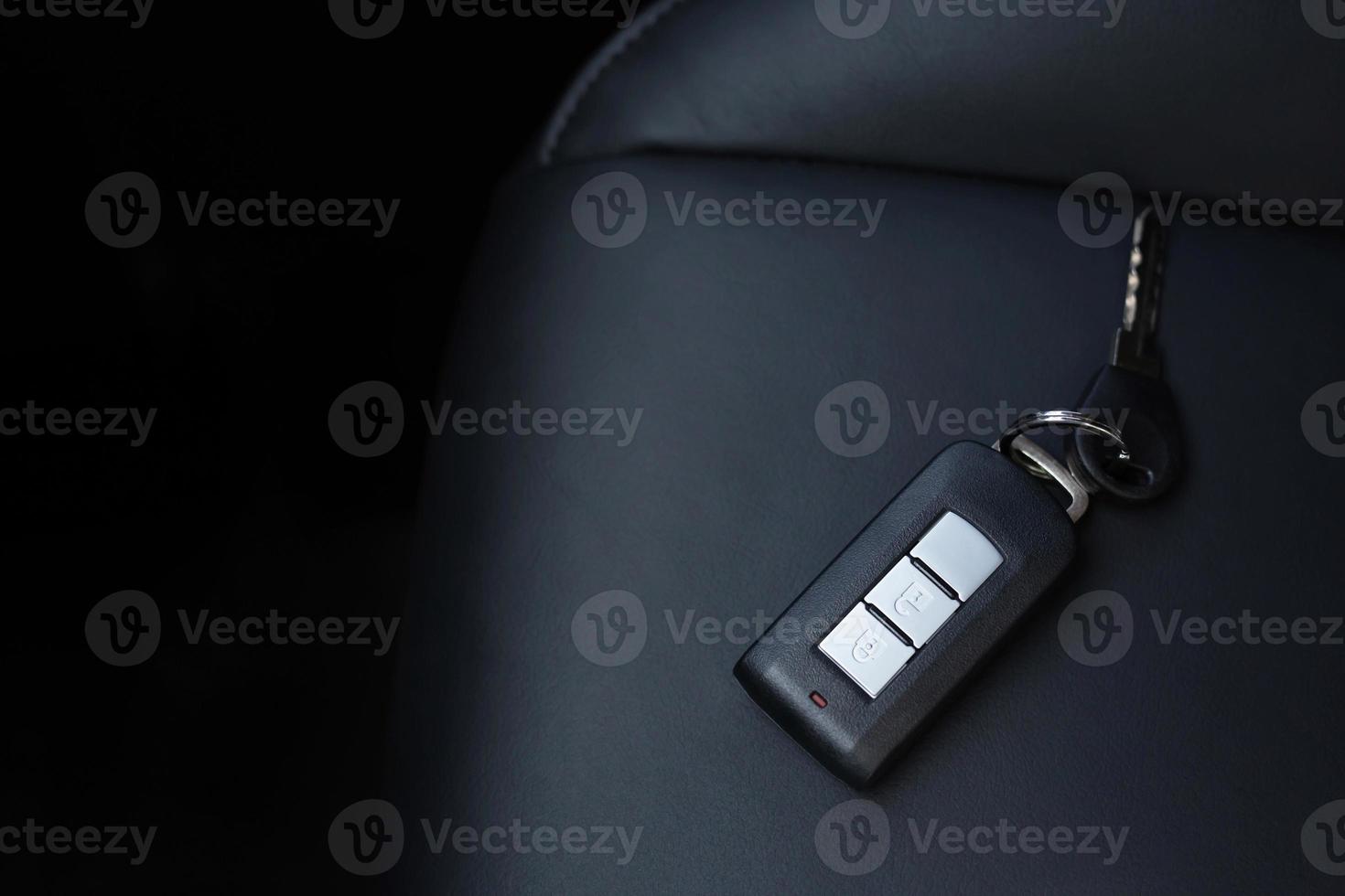 Close up of a car key ring and remote control alarm system charm in vehicle new car interior or Forget keys placed on the leather seats. soft focus. photo