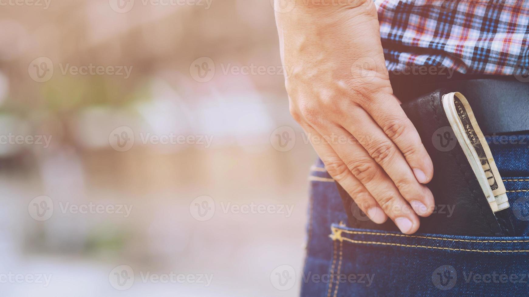 Confident business man posing in safe keeping your wallet in the back pocket of his back pocket pants. savings money. photo