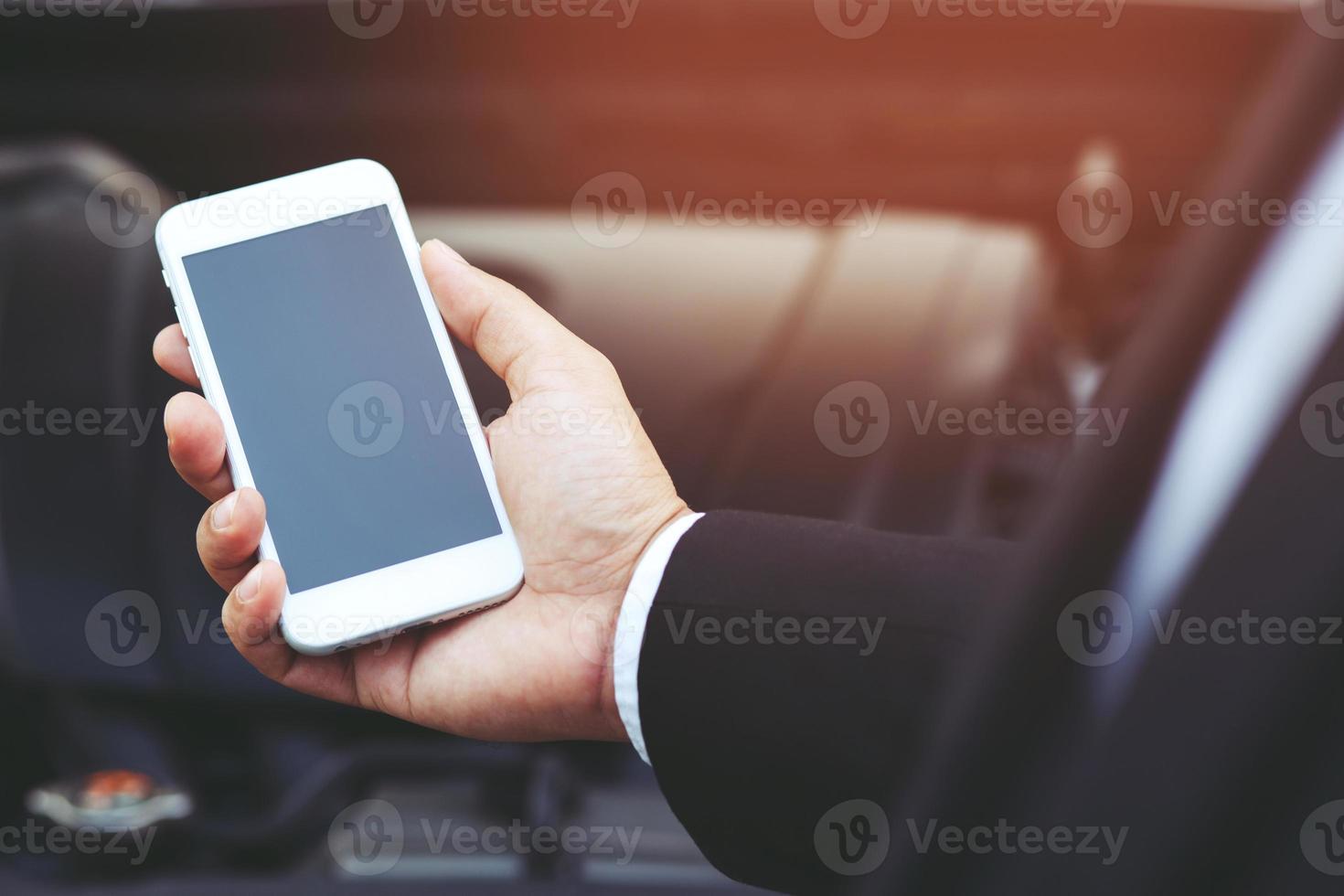 close up businessman hand using a mobile smart phone call a car photo