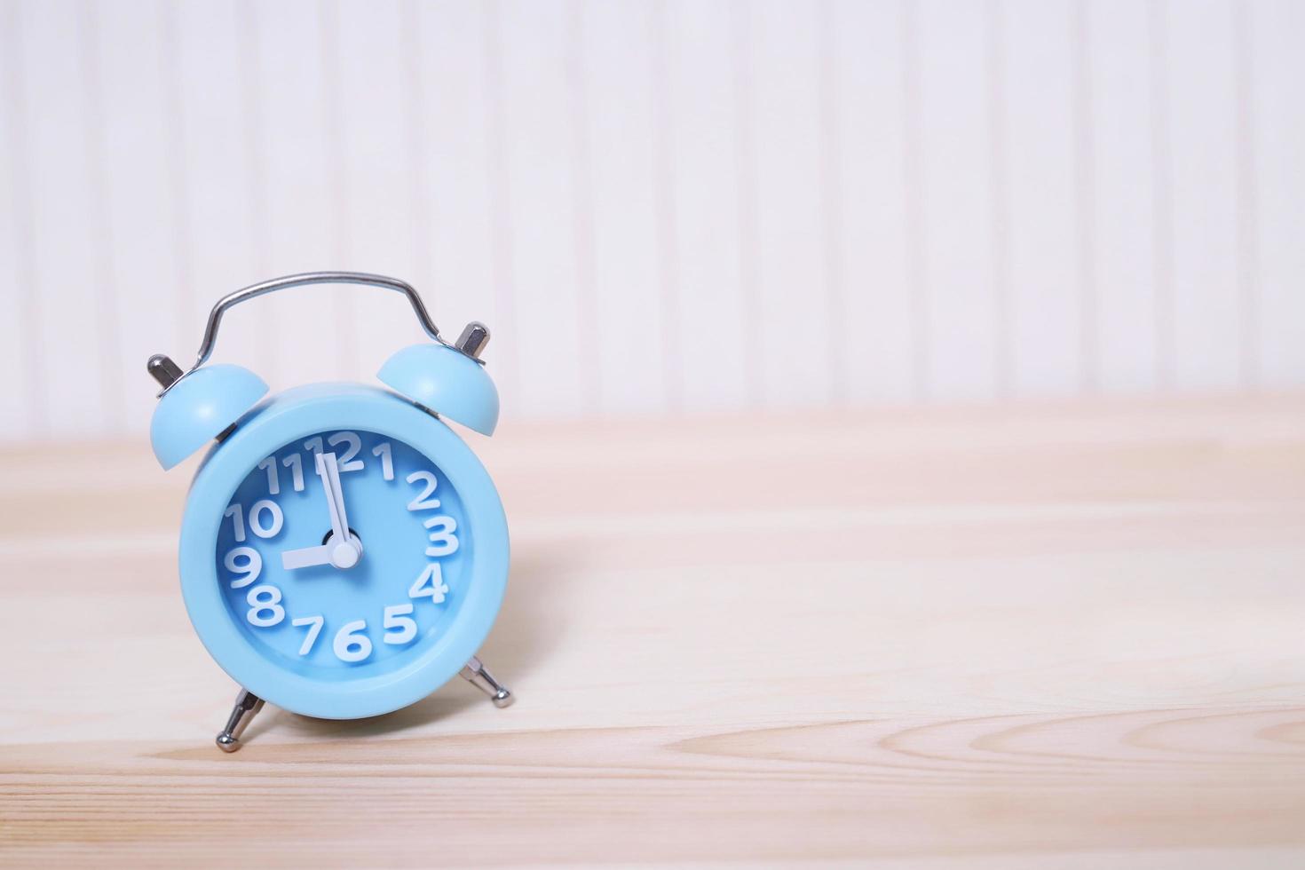 small sized old vintage retro alarm clock blue with bells , on wooden background wallpaper. photo