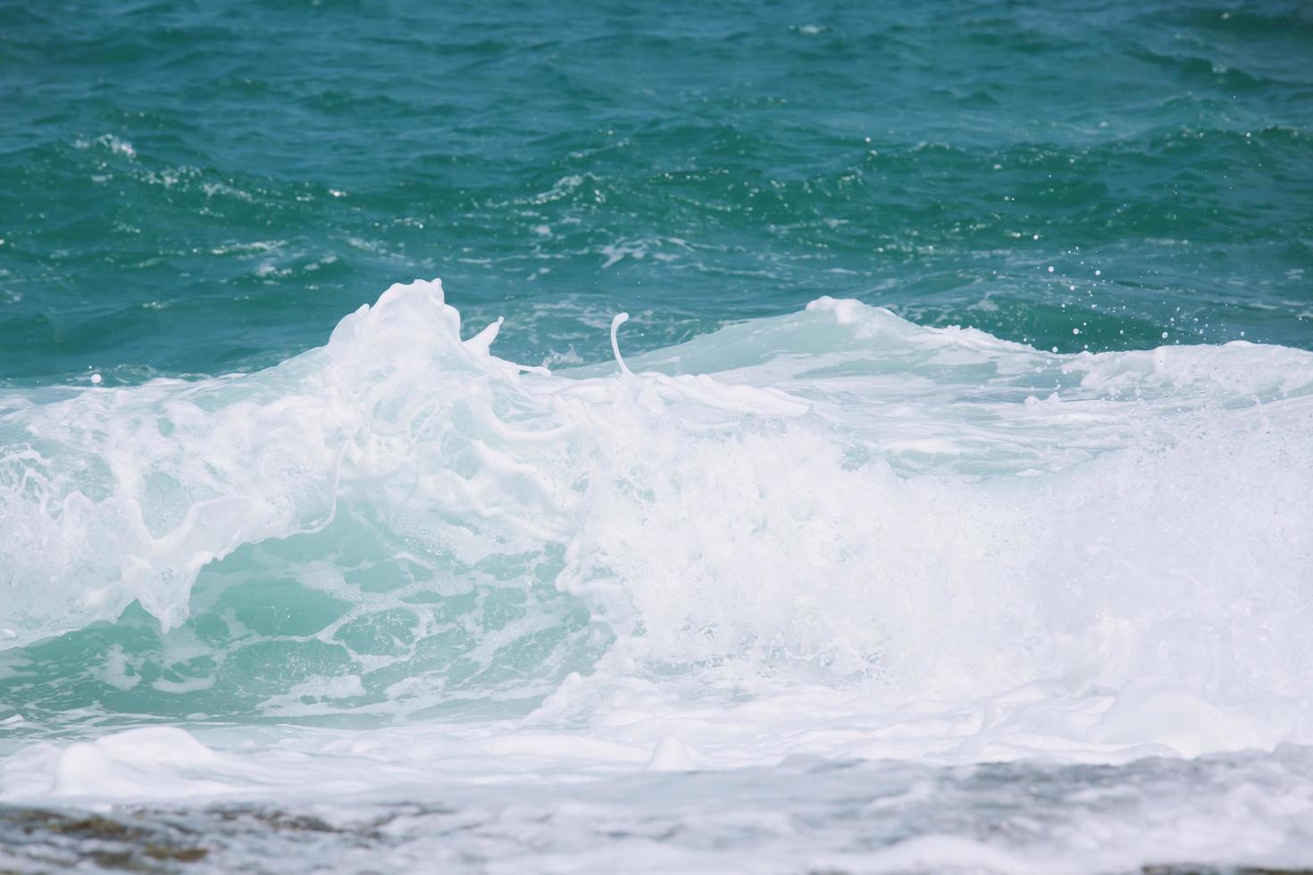 olas del mar en las olas del océano salpicando agua ondulada. fondo de agua azul. foto