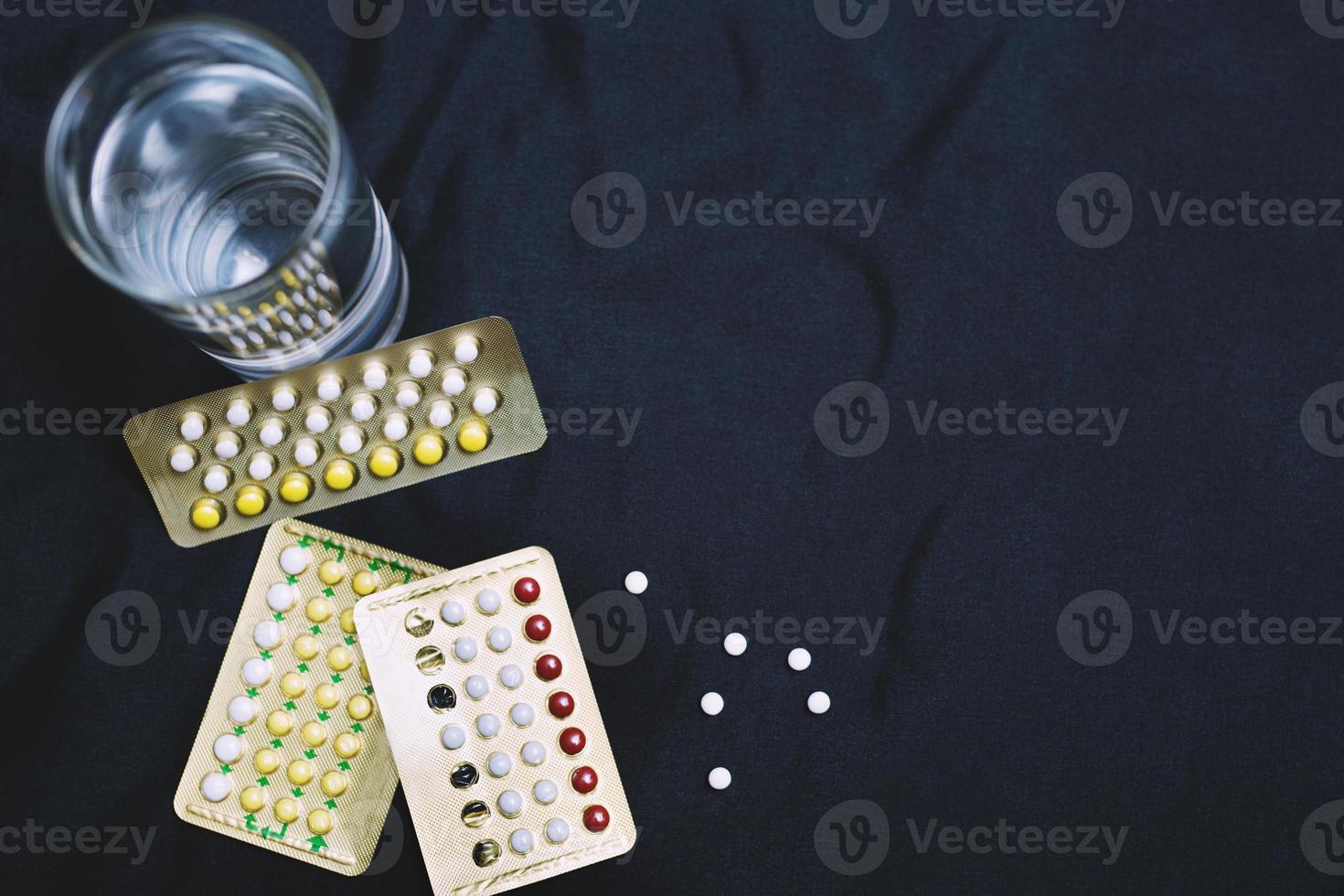 A glass of drinking water and opening birth control pills. Taking