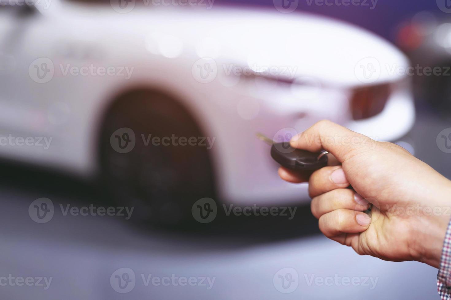 Car key in business man hand.  hand presses on the remote control alarm systems. lock or unlock the door. photo