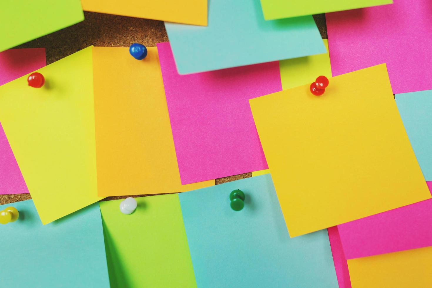 collection of colorful variety post it. paper note reminder sticky notes pin on cork bulletin board. empty space for text. photo