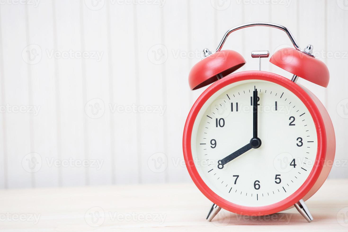 Red alarm clock set at three isolated over white background photo