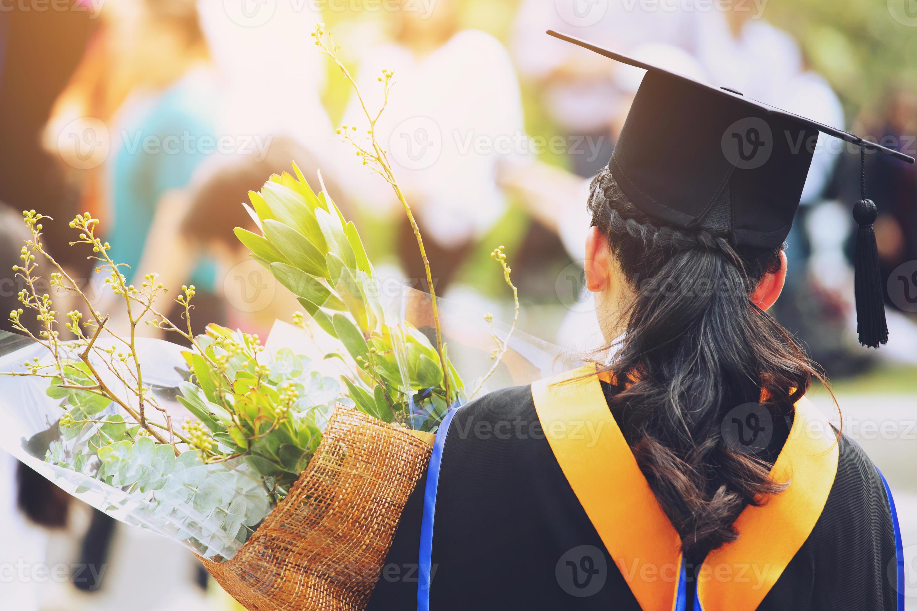 shot back side young female student in hand holding a bouquet of