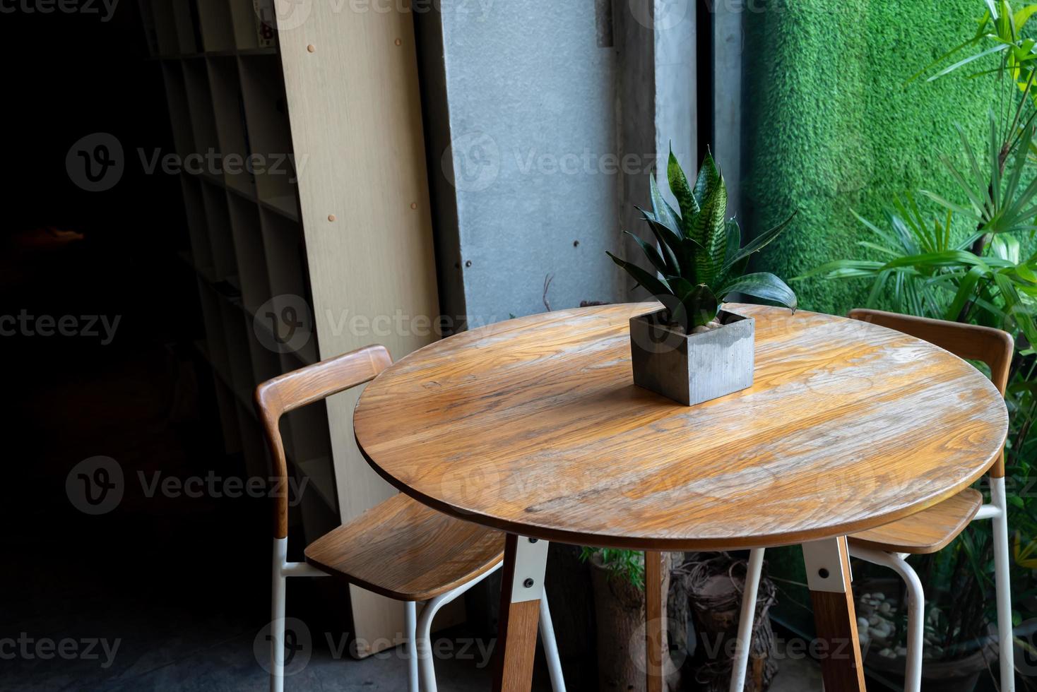 Coffee table or leisure corner table with natural light from window. Plant and vase is decorated on the table. photo