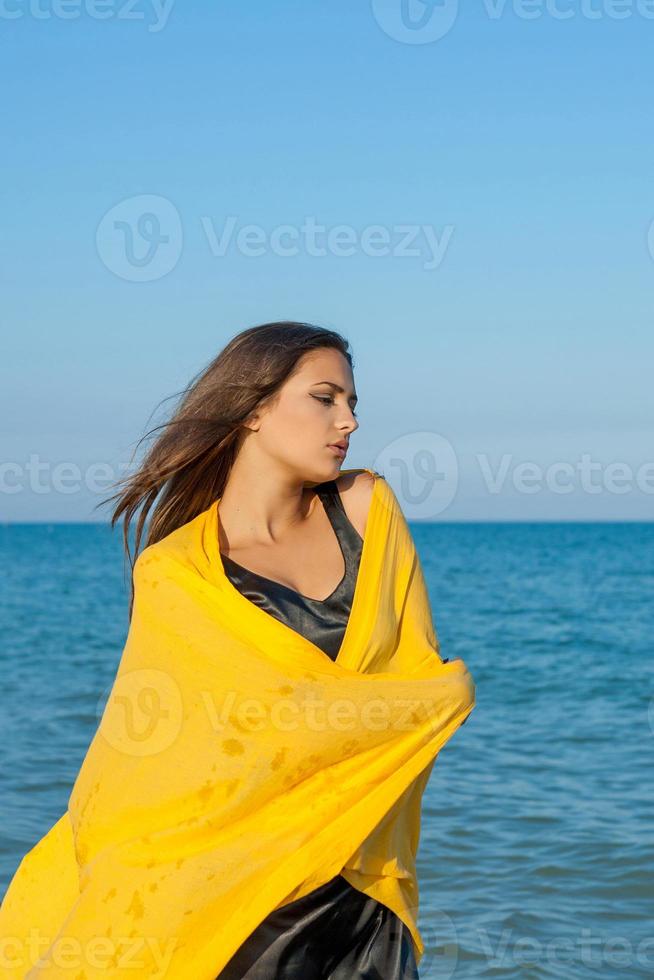 Young sad girl near sea on sunset photo