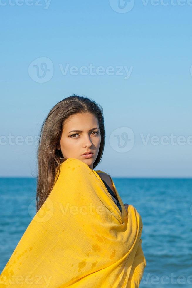Young sad girl near sea on sunset photo