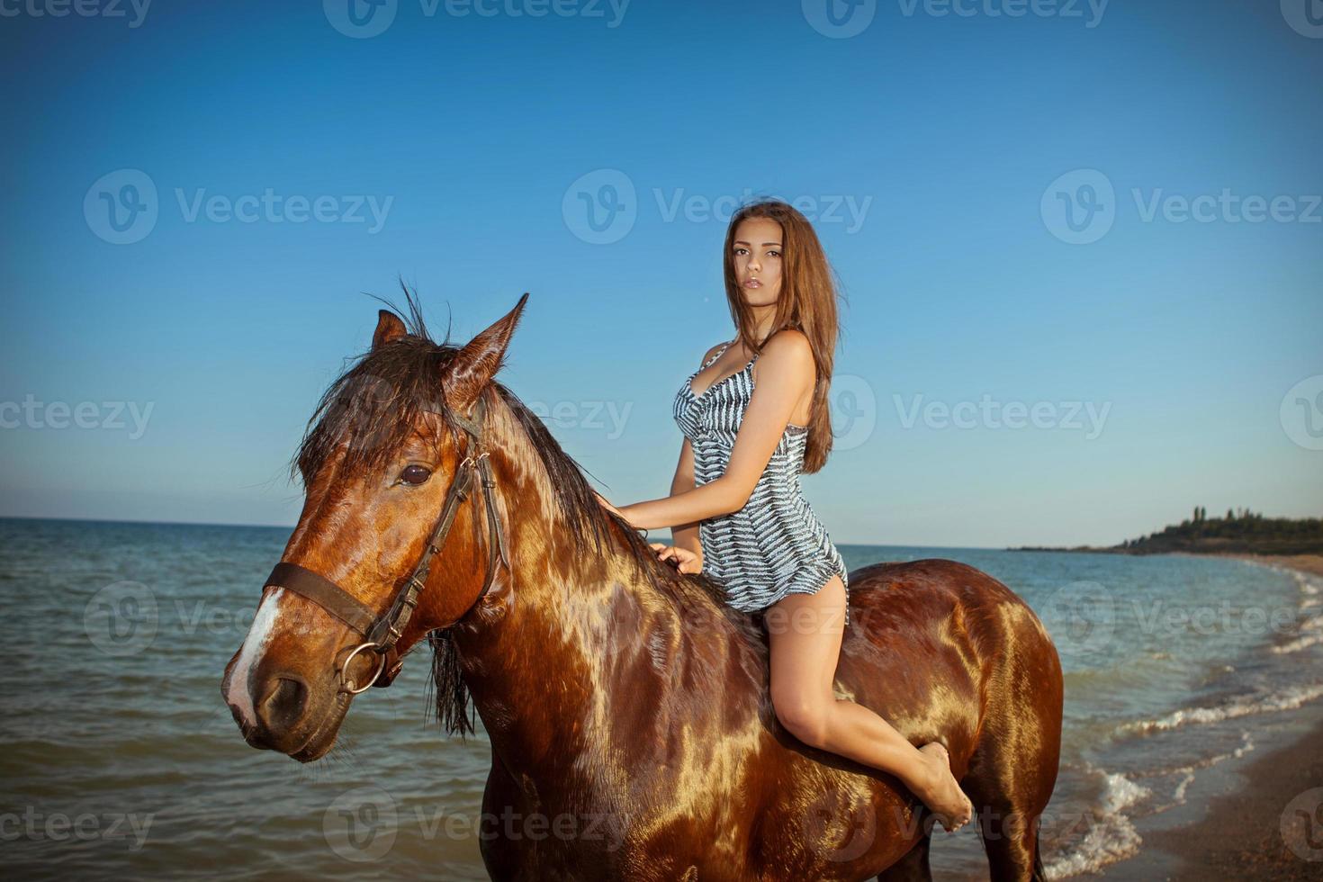 young woman evening beach horse ride photo