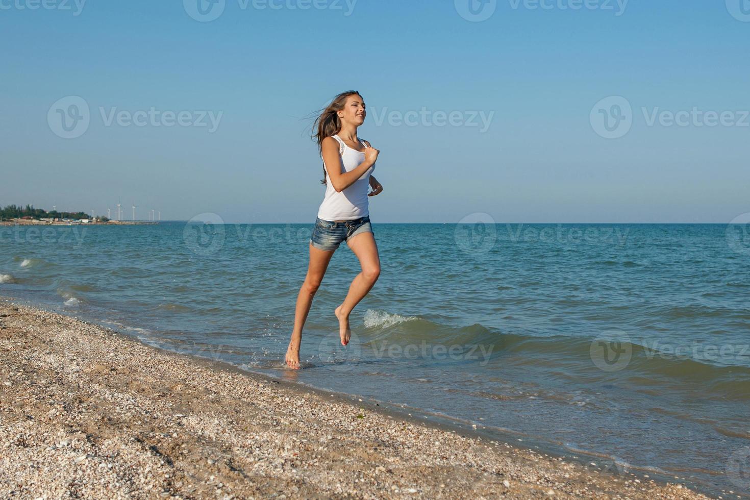 niña corre en el mar foto