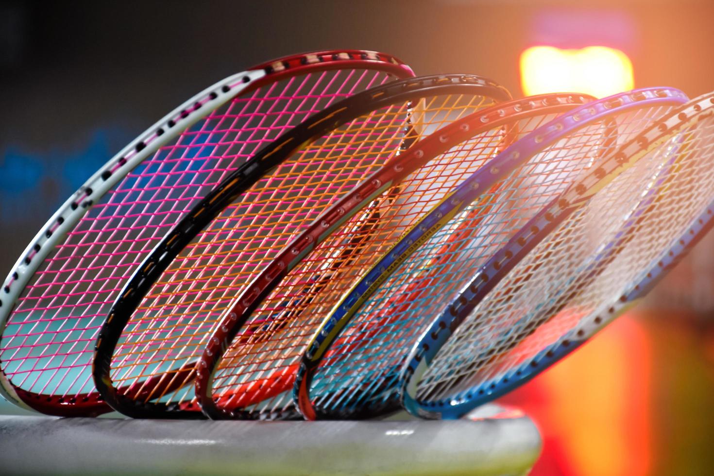 Badminton rackets for badminton playing in indoor badminton court  with neon light shading on green floor, blurred badminton background, copy space. photo