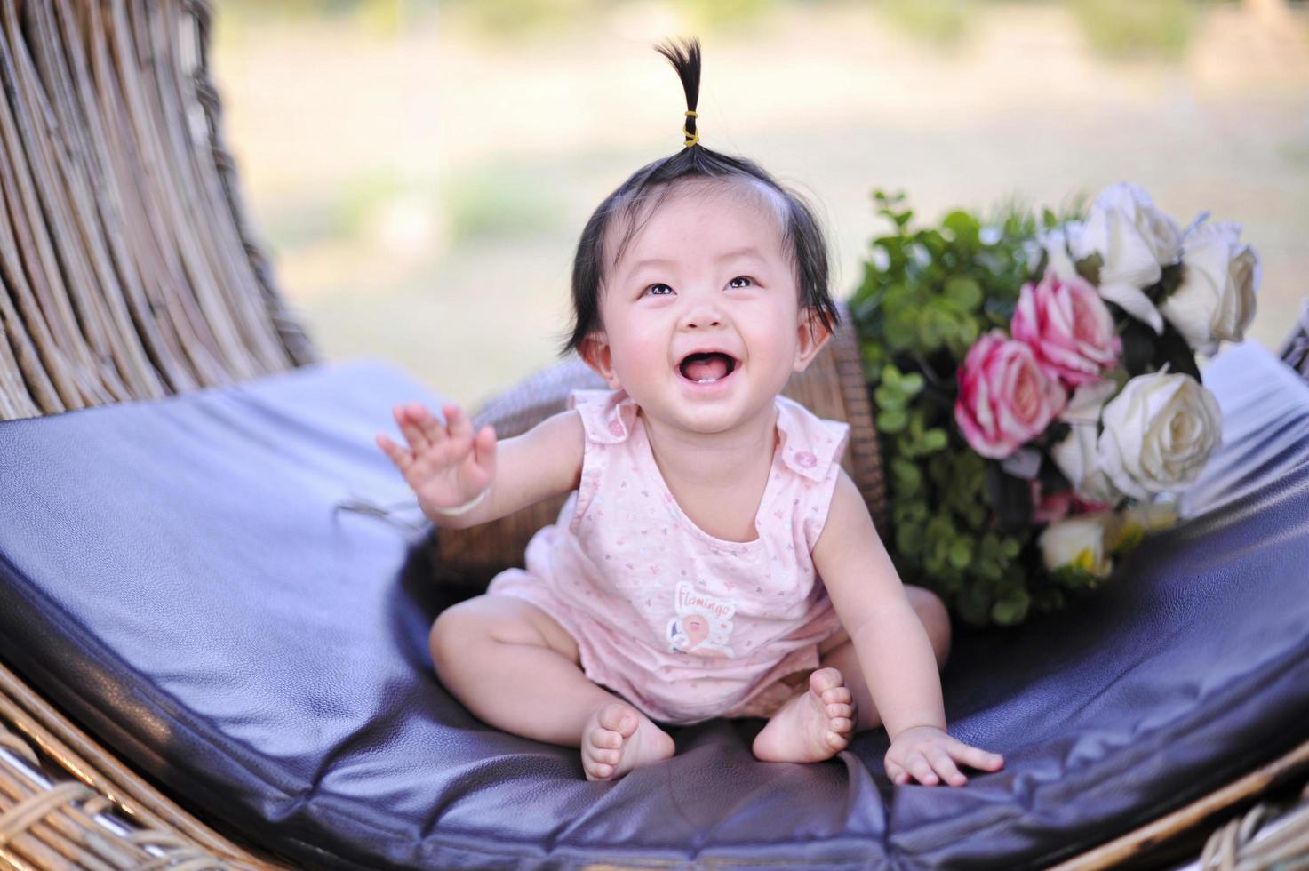 Portrait asia baby girl of 8 months old enjoying, Closeup cute child happy in pink dress. photo