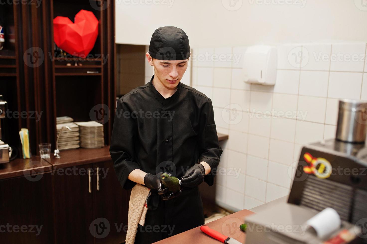 Professional chef wear in black making sushi and rolls in a restaurant kitchen of japanese traditional food. photo