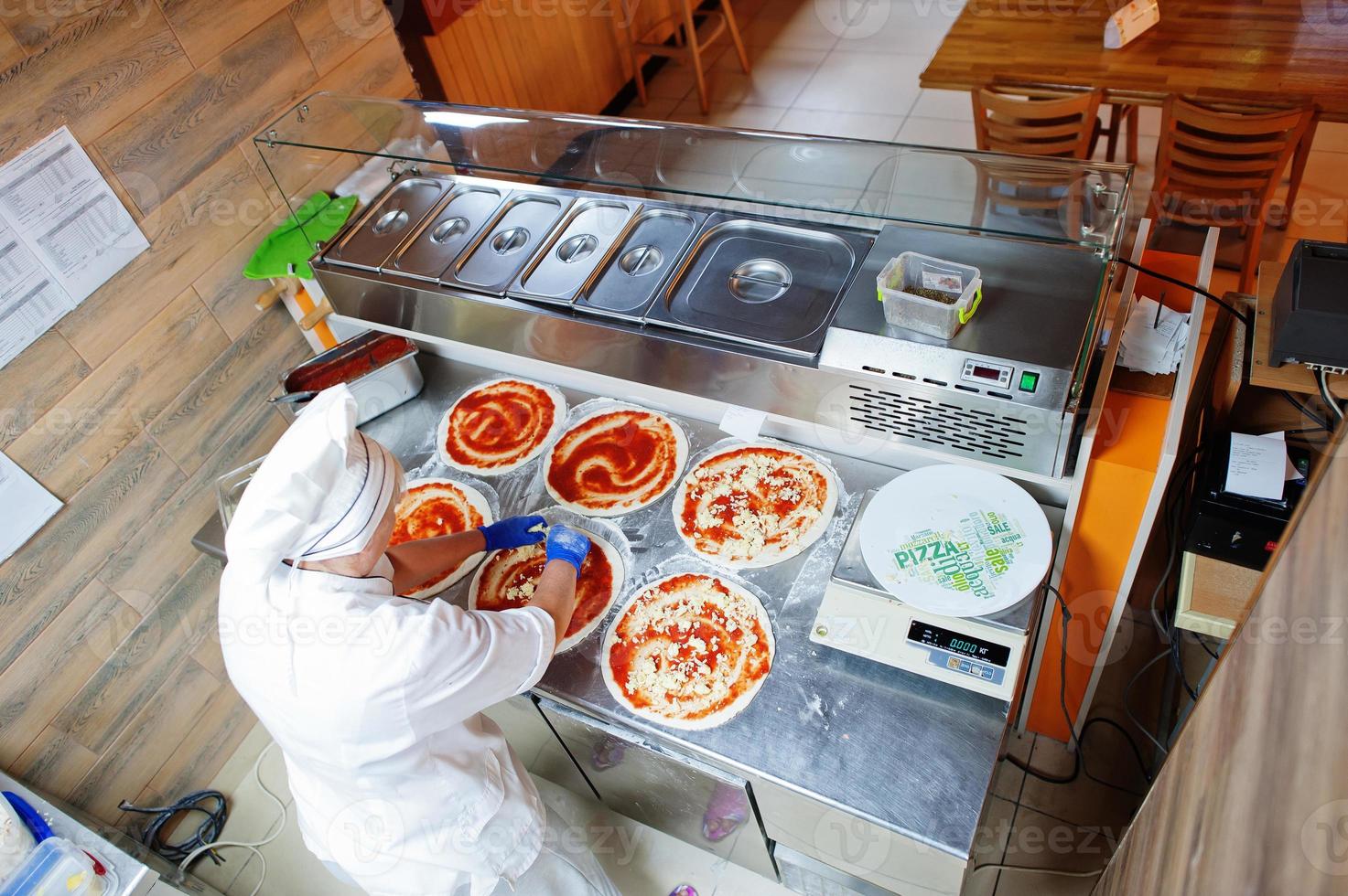 cocinera preparando pizza en la cocina del restaurante. foto