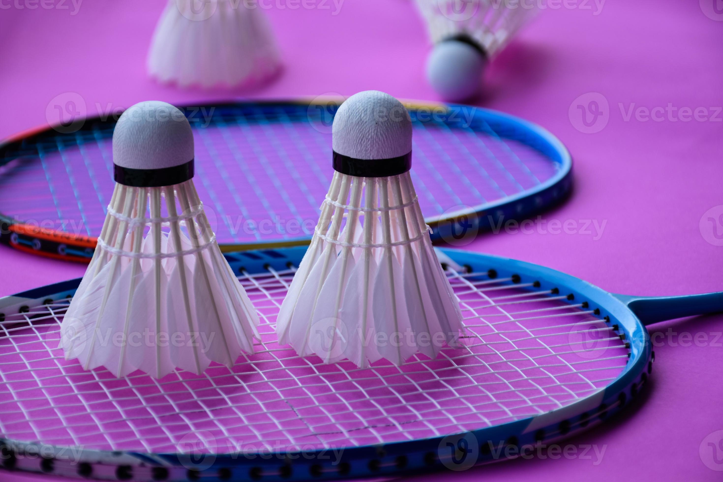 badminton shuttlecock and racket with neon light shading on green floor