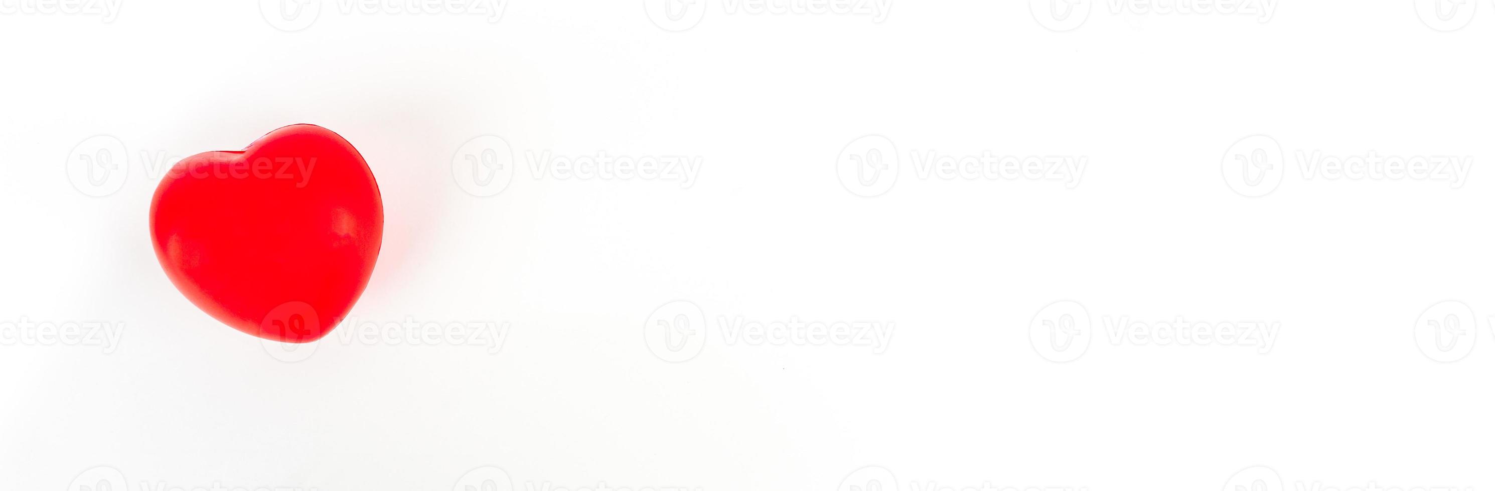 The red heart represents the love provided on a white background. photo