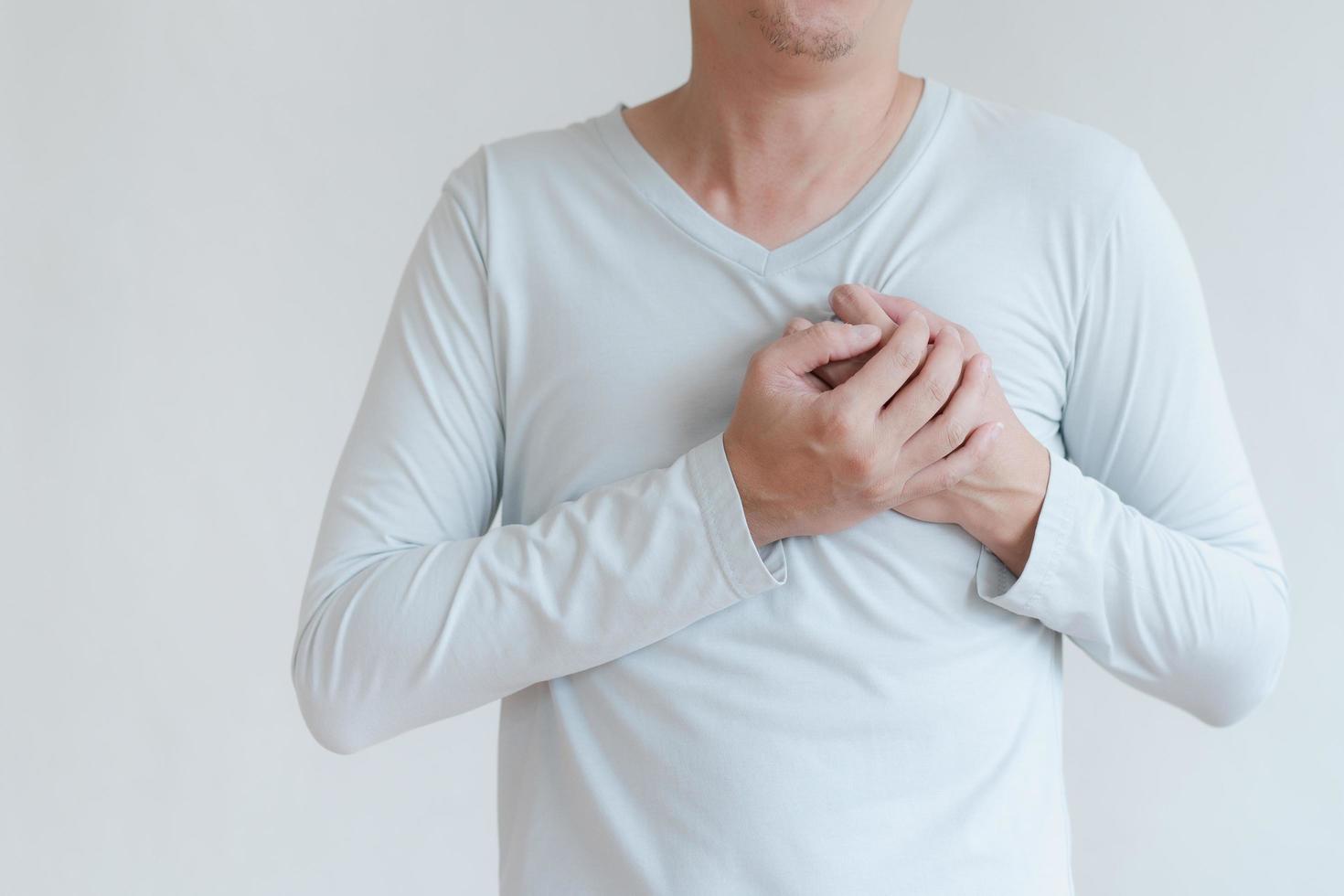 un hombre que toca su corazón, con un punto culminante rojo de ataque al corazón y otros concepto de enfermedad cardíaca, síntoma de ataque al corazón foto