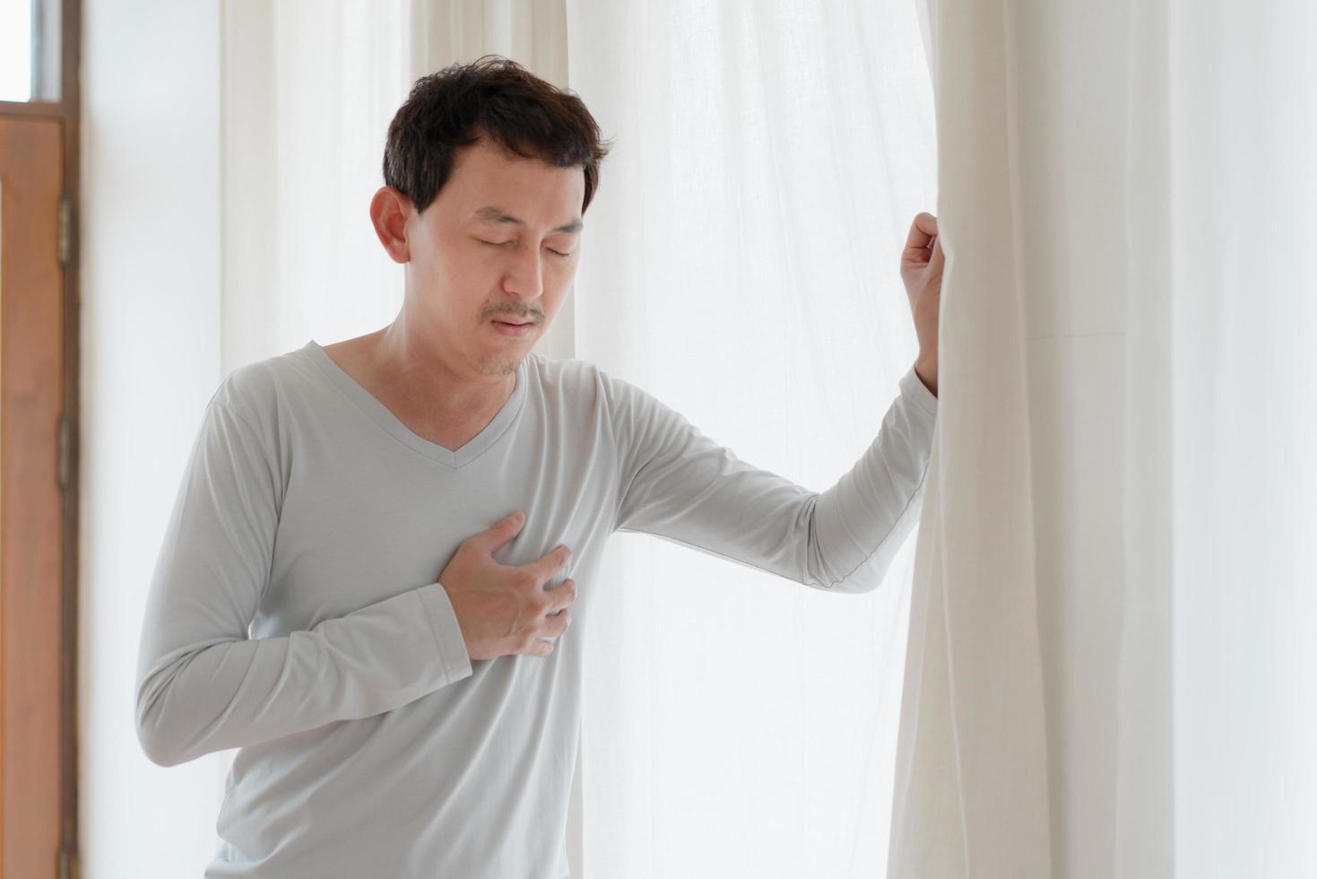 a man touching his heart, with red highlight of heart attack, and others heart disease concept, Heart attack symptom photo